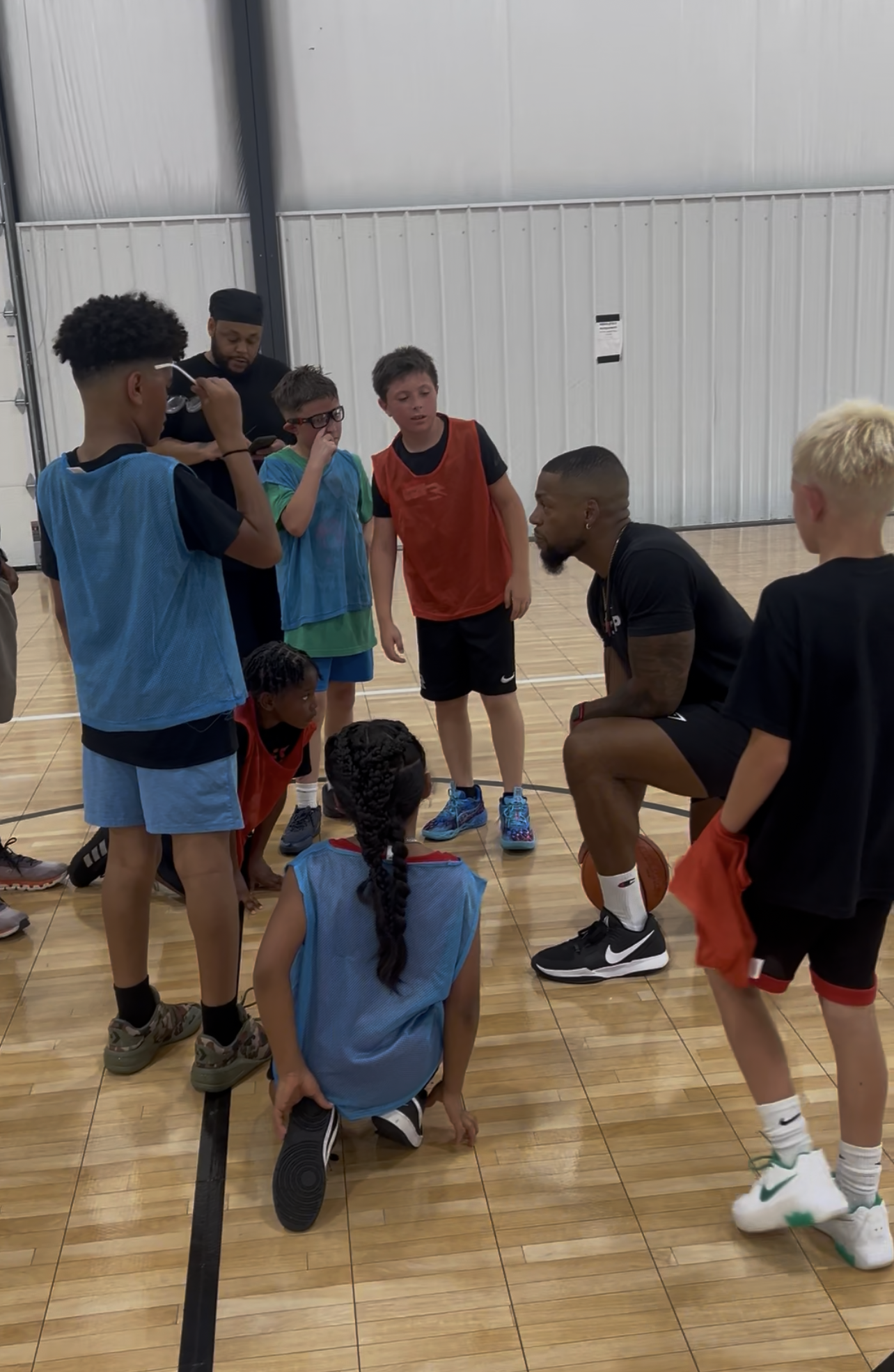 Coach mentoring young basketball players during a Gary Family Foundation youth sports program.