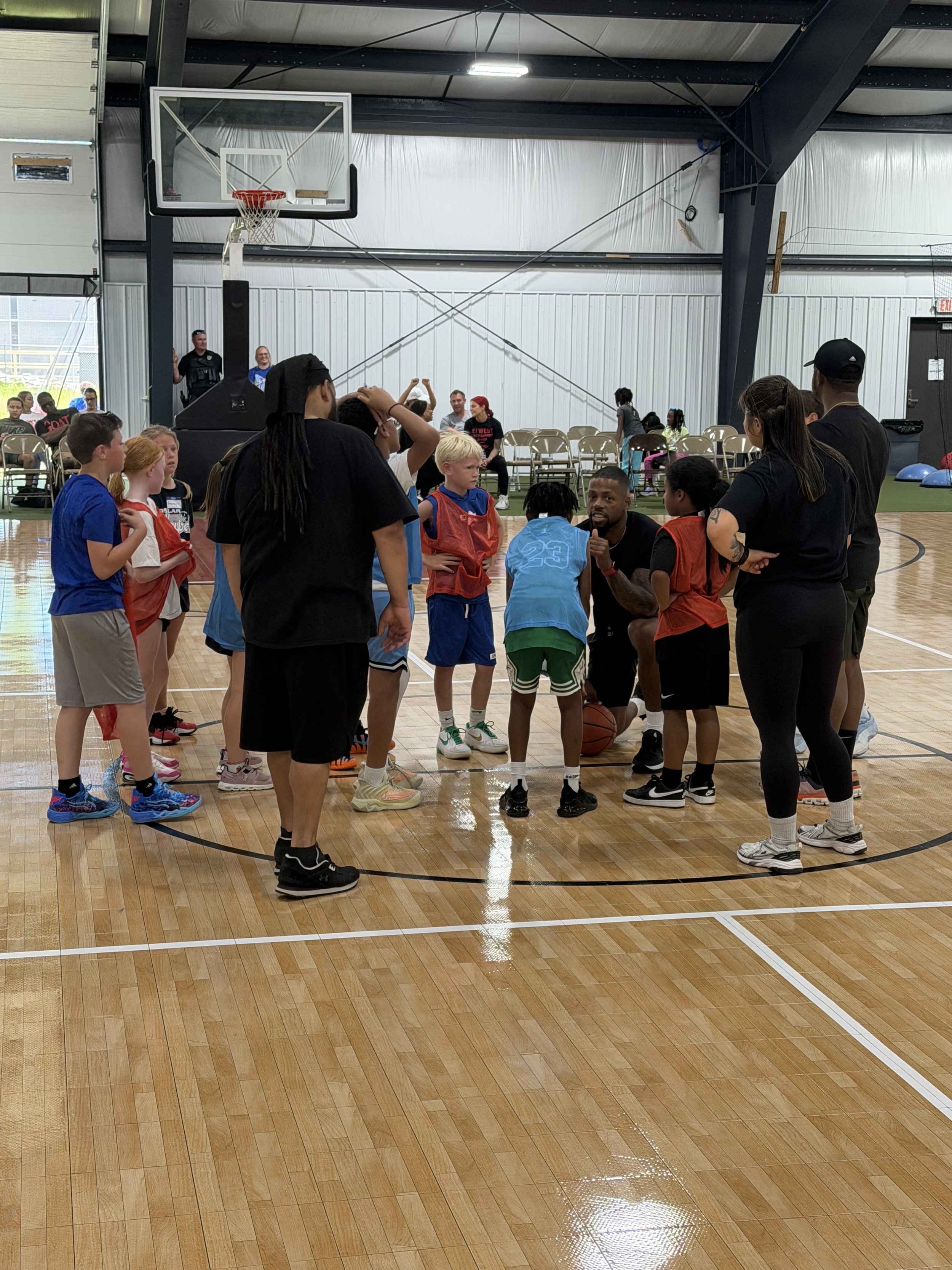 Coach providing instruction to a young basketball player during a Gary Family Foundation youth program.