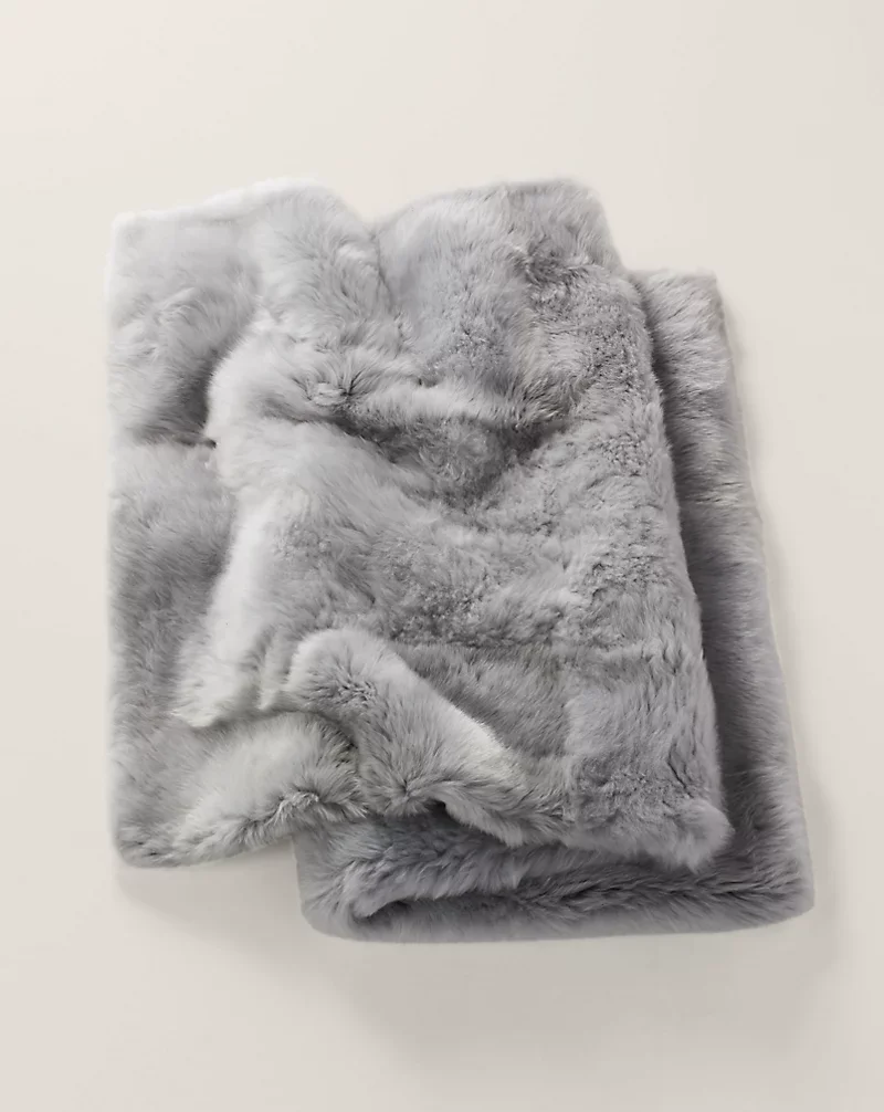 Folded gray shearling throw on a light background.