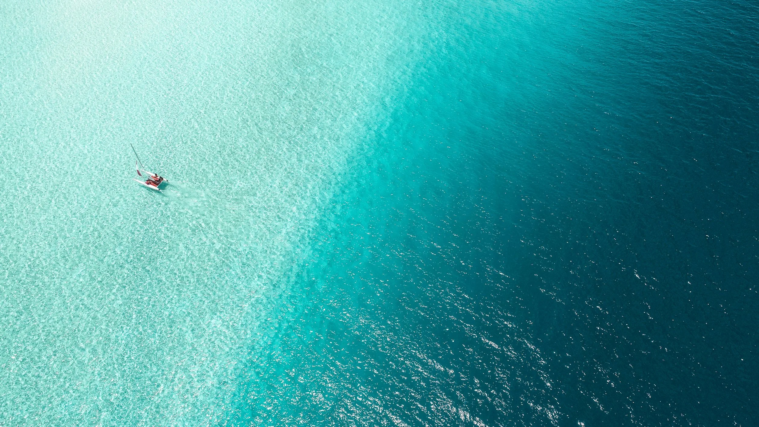 Kayaker exploring ocean going from shallow to deep water signifying the progressive work of trauma therapy