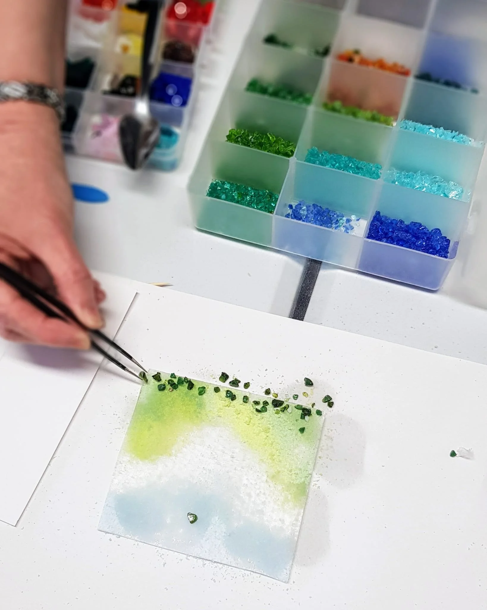fused glass hand using tweezers to work with tiny pieces of glass