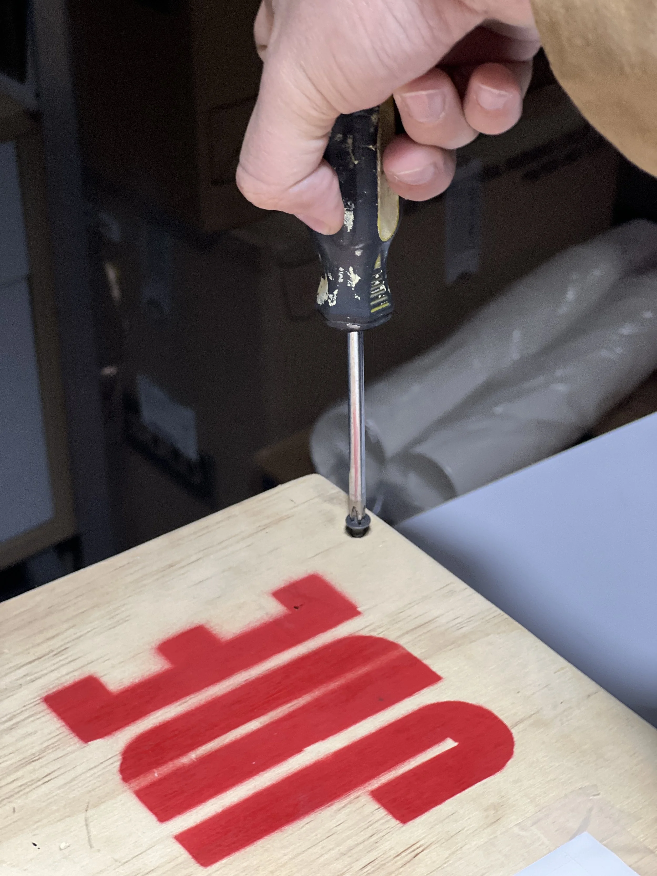 Prueba de materiales y herramientas durante la construcción manual de una maqueta de diseño con logo JDE design.