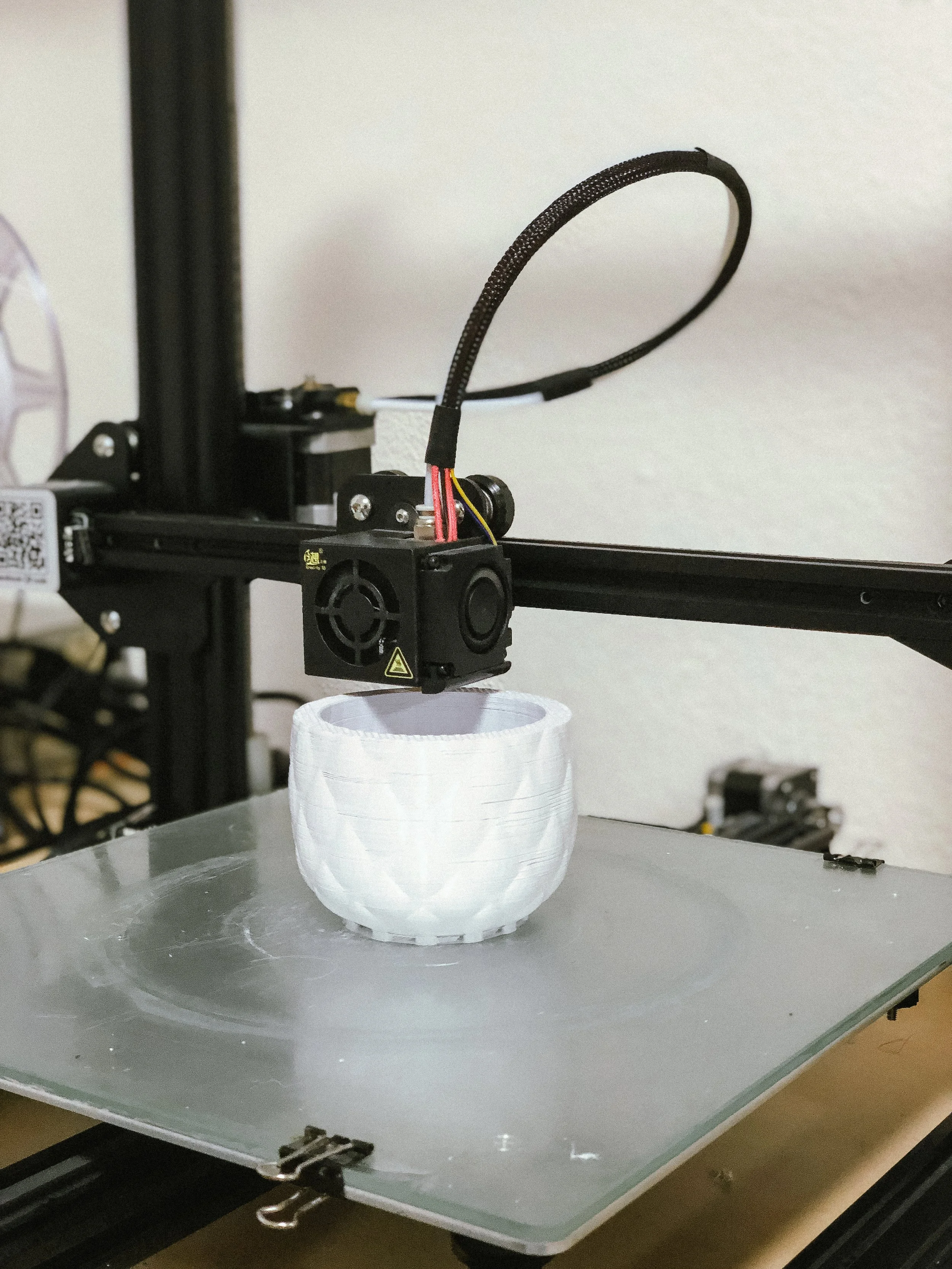 Impresora 3D fabricando un prototipo de lámpara Decimal mediante deposición de material.