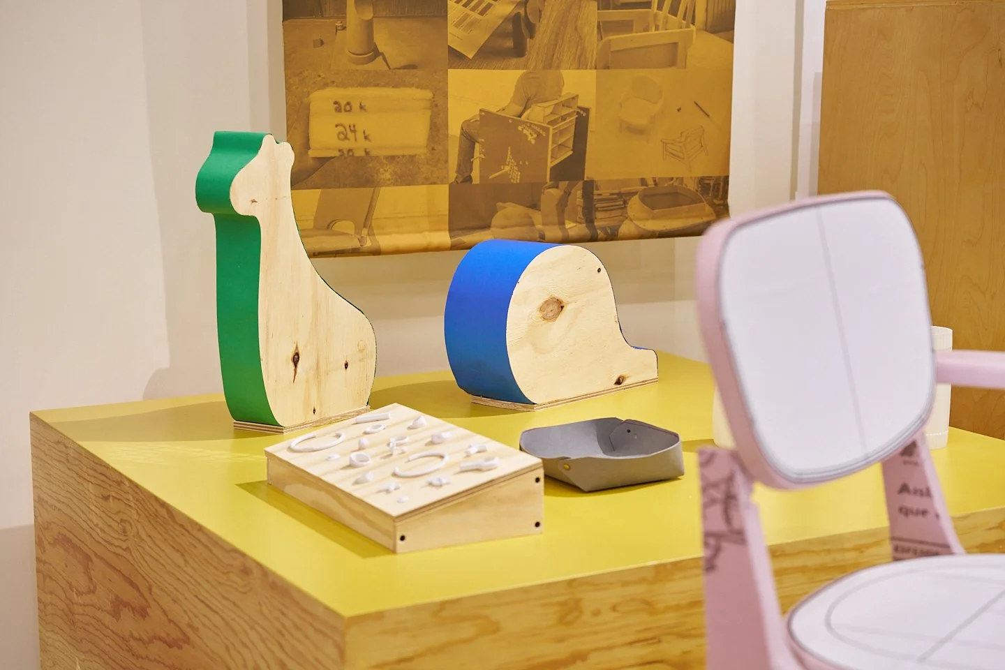     Prototipos de madera y objetos experimentales exhibidos sobre una mesa como parte del archivo de diseño industrial.