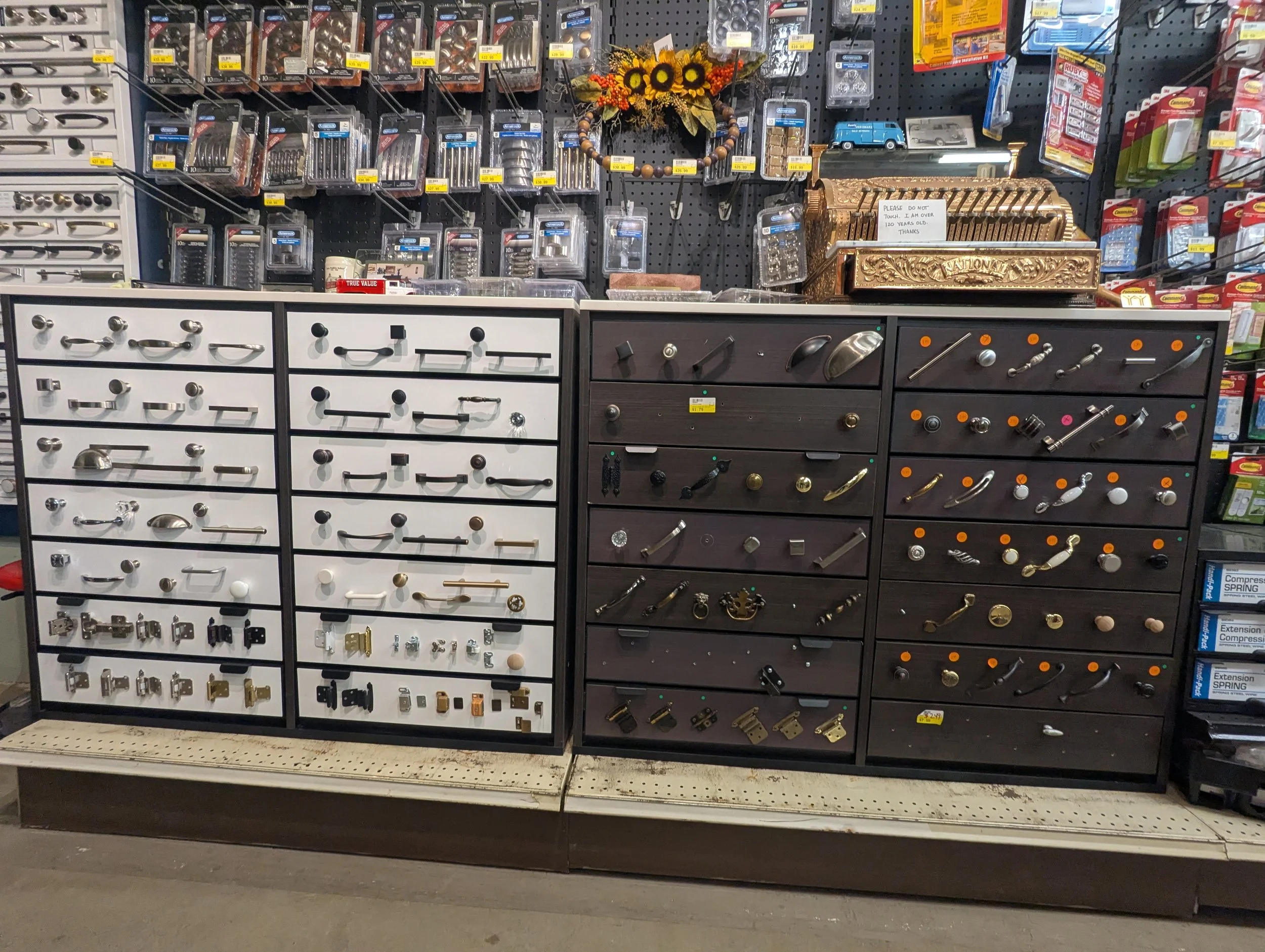 Display of cabinet hardware such as knobs, handles, locks, and hinges in a hardware store.