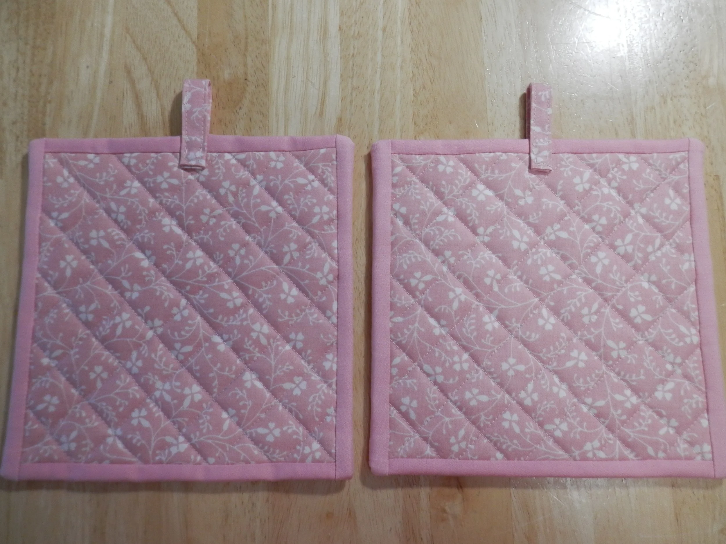 Ivory Flowers Silhouetted on Mauve Potholders Set of 2
