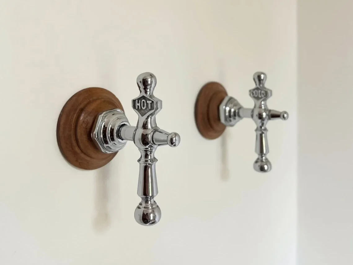 Custom coat hangars made from repurposed antique shower knobs.