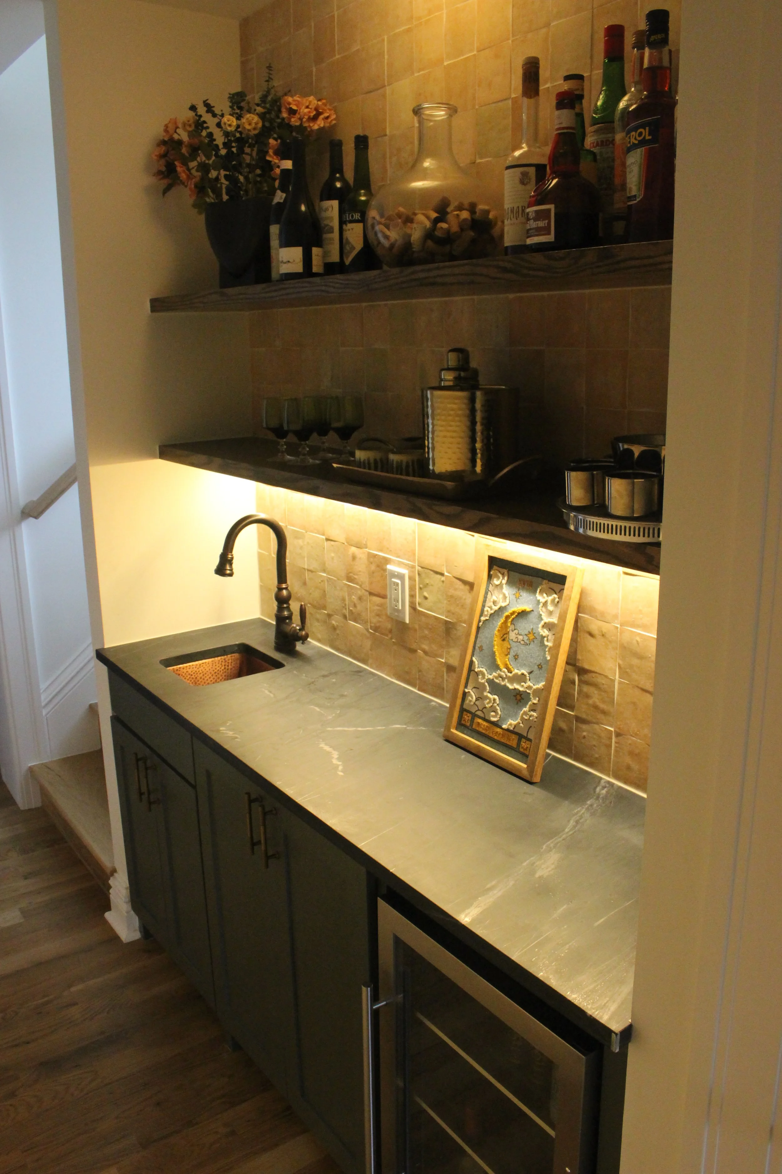 a built-in mini-bar with a sink and mini fridge.