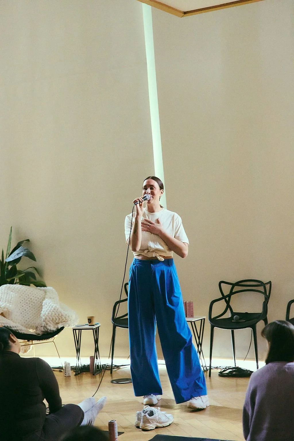 Rachel Molenda wearing blue pants and white tshirt on a microphone MC-ing at brand activation