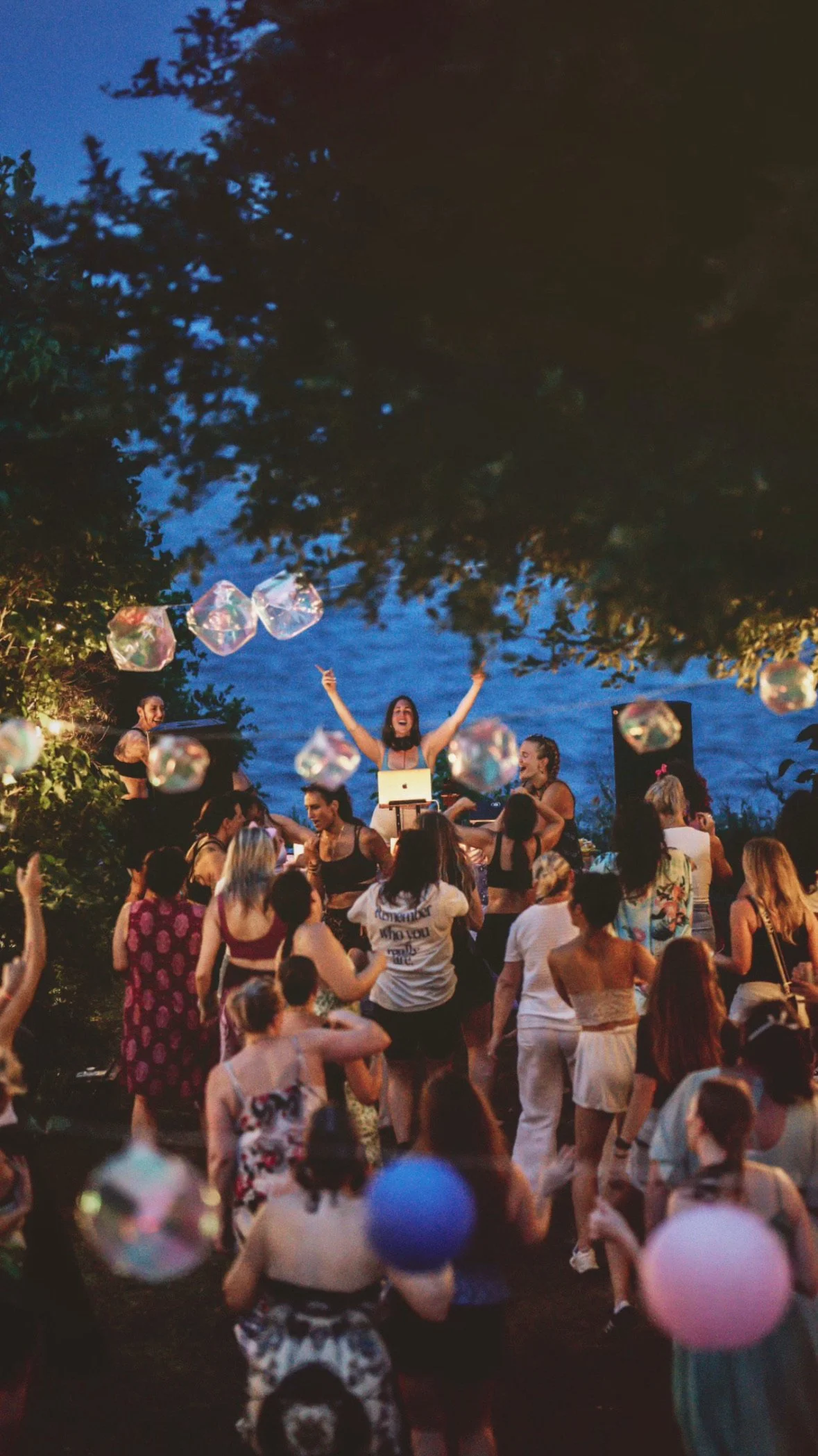 Rachel Molenda DJ-ing at a REUNION Dance party event outdoors with women dancing in the crowd