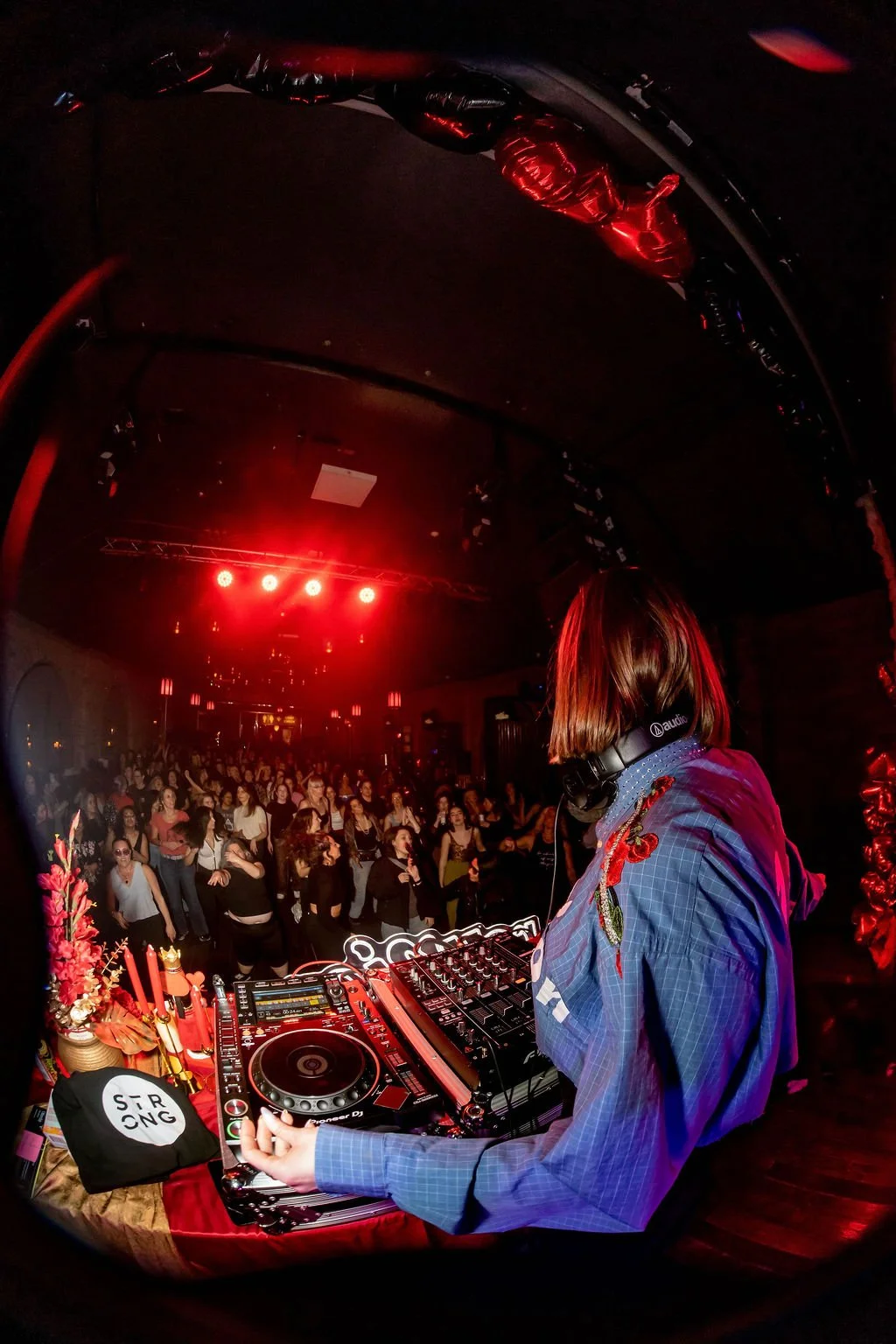 Rachel Molenda wearing blue custom REUNION button up blue shirt DJ-ing at REUNION Dance party event