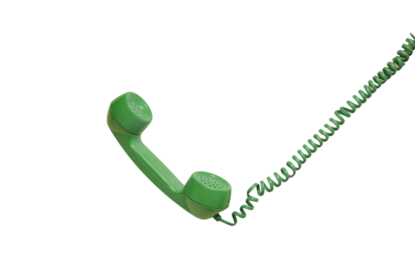 A vintage green corded telephone with a rotary dial, resting on its side with the receiver detached.