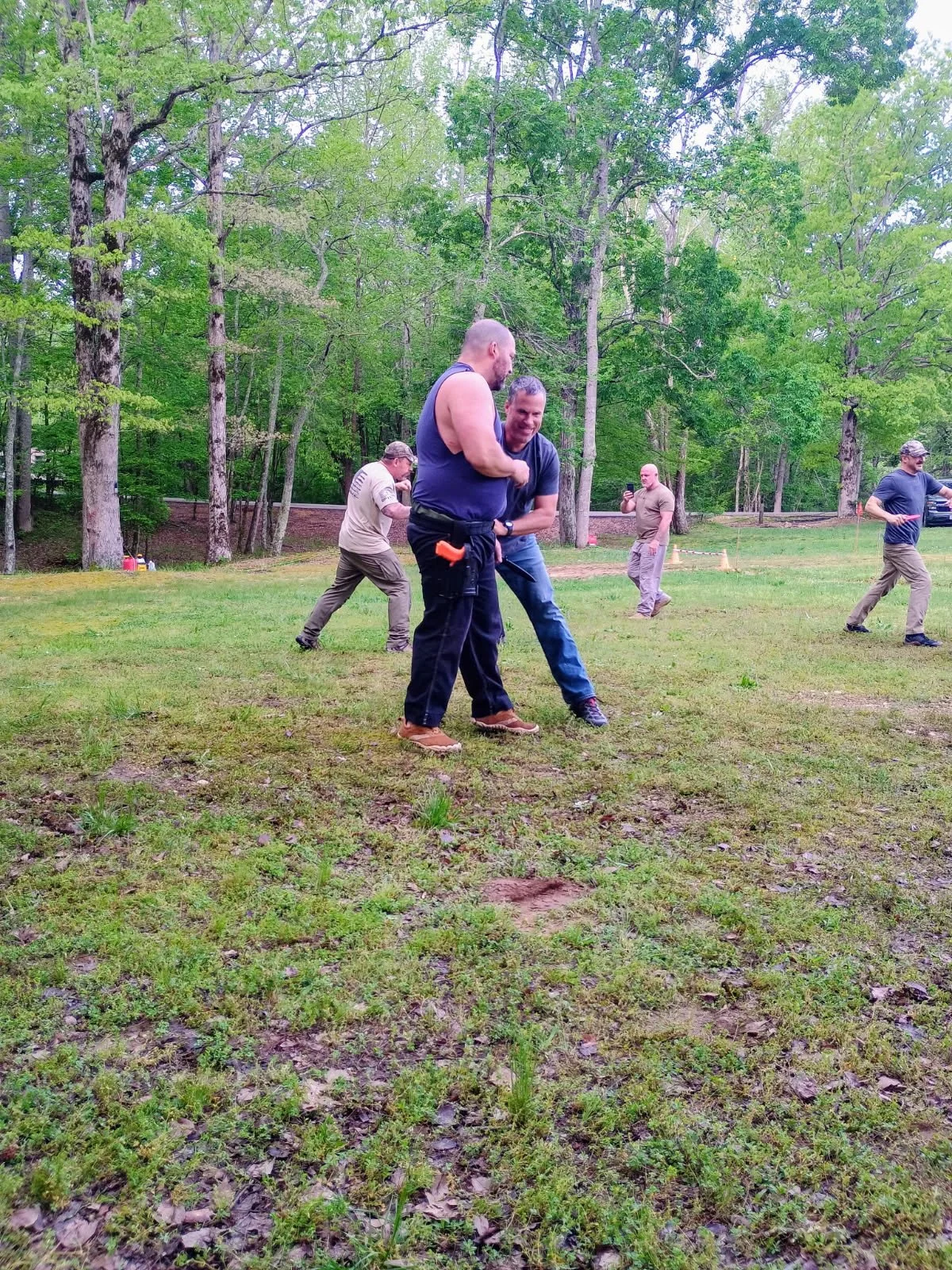Kraken Combatives participants practicing hands-on personal protection drills outdoors.