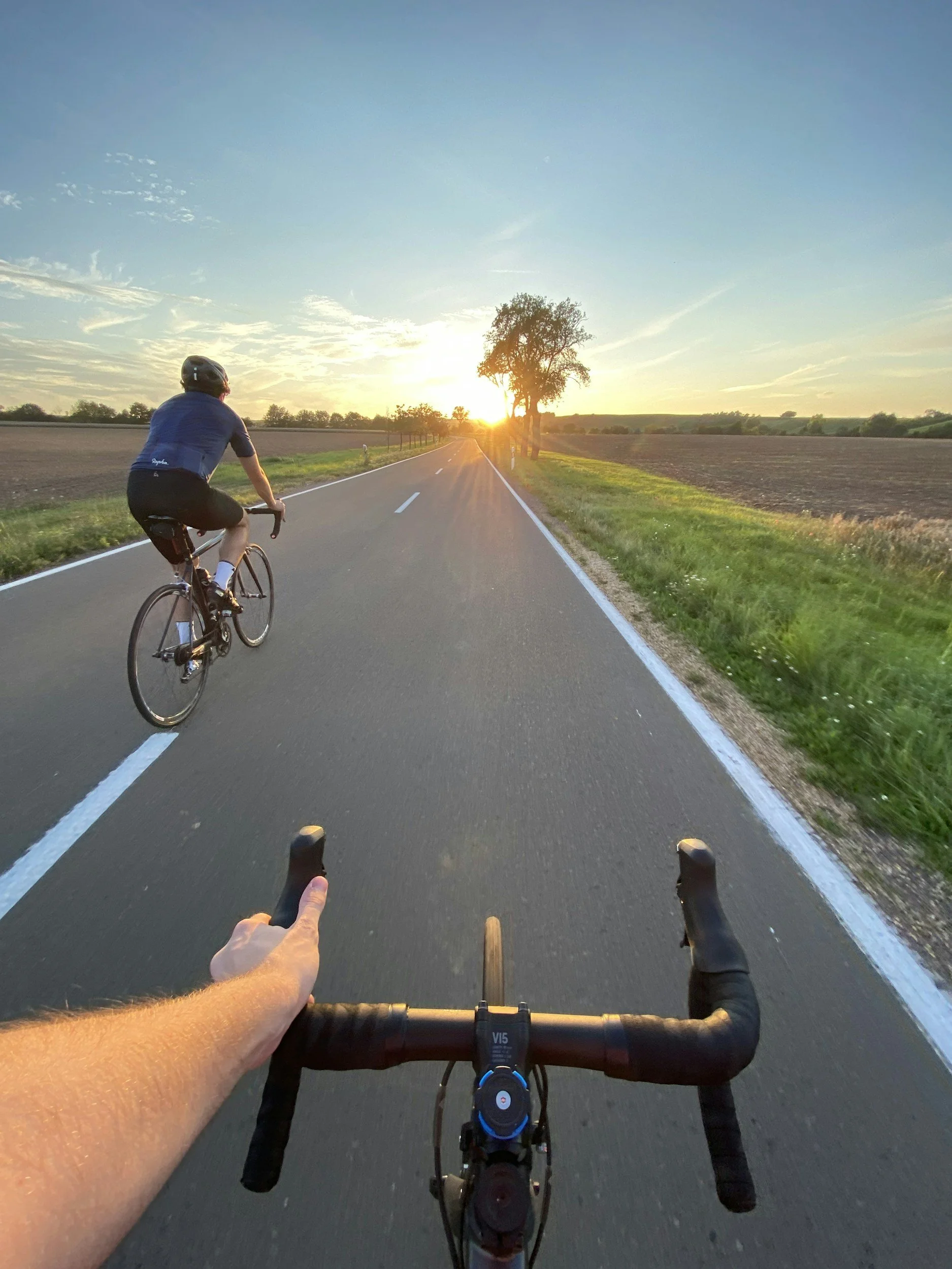 two people peddle biking down the road