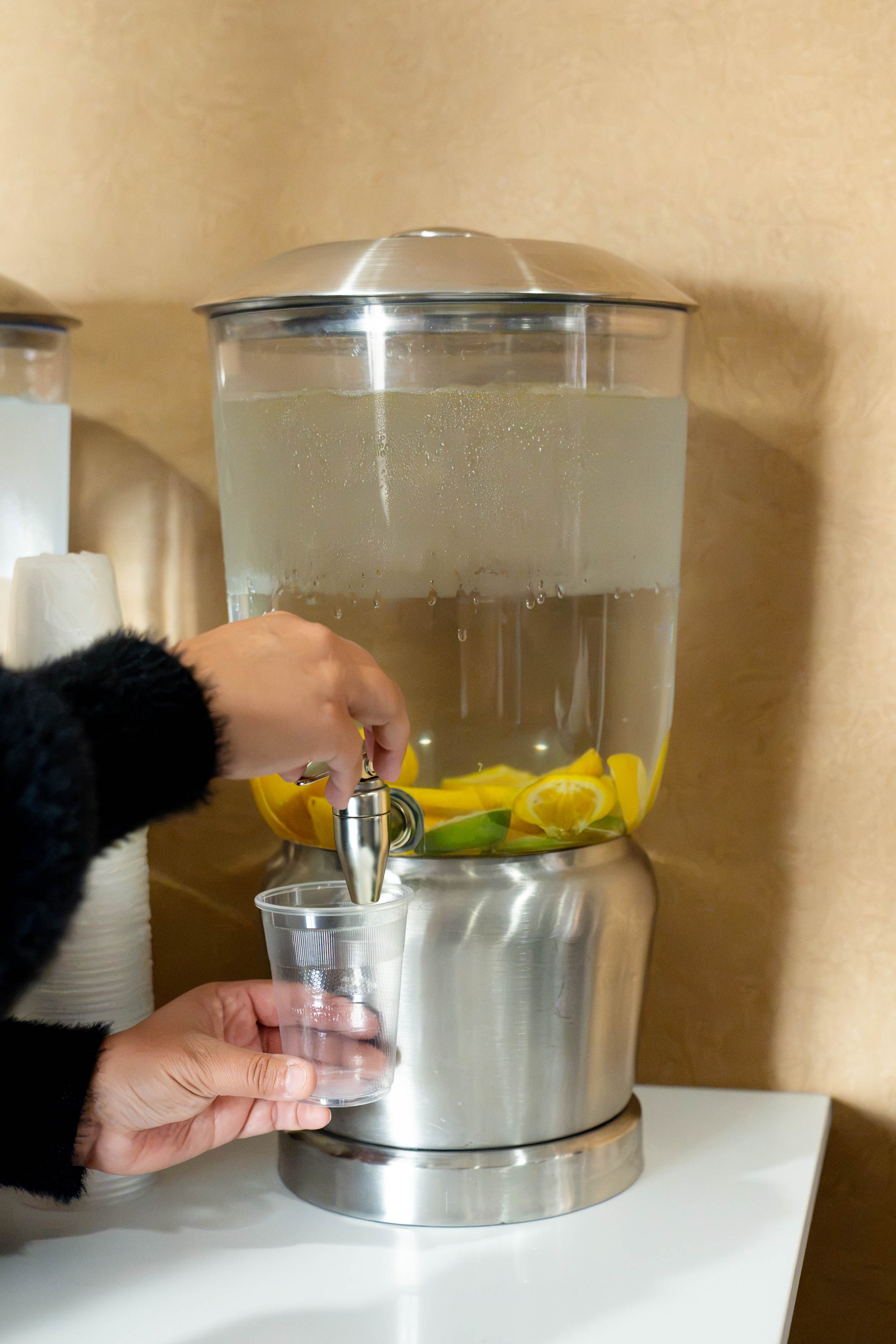 women pouring complimentary lemon infused water into a cup