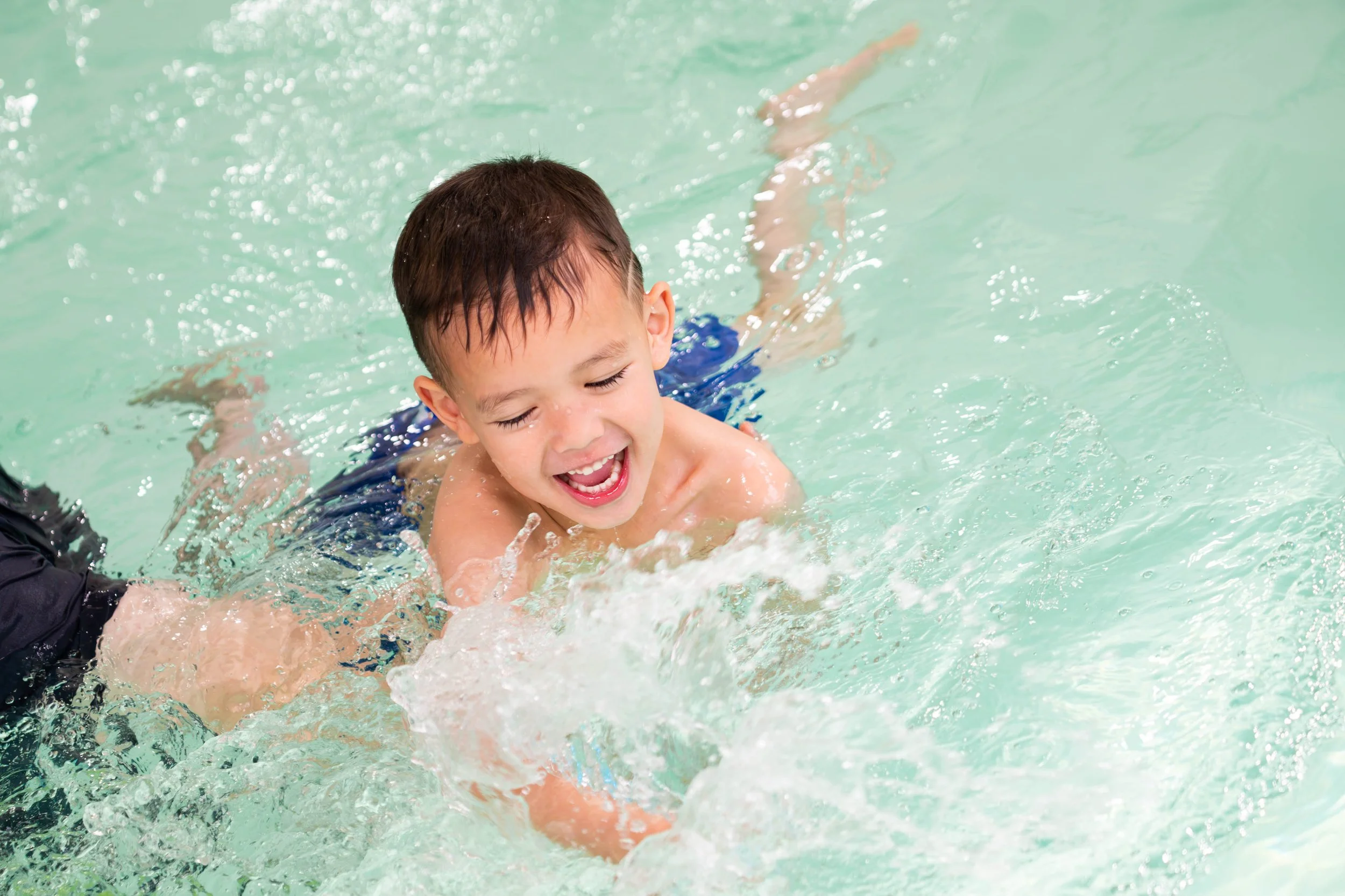 young boy playing in the pool