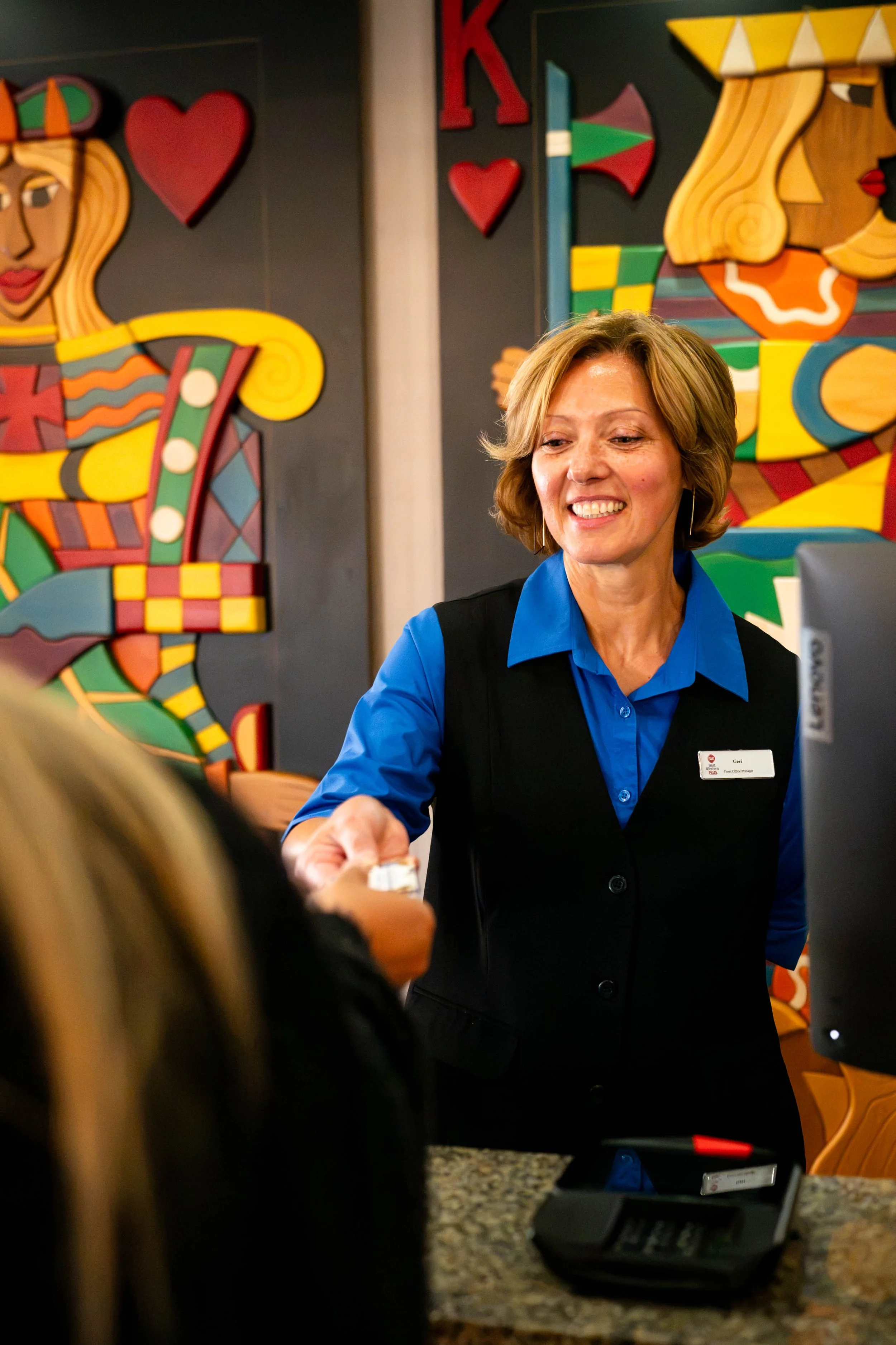 Front Desk employee welcoming a guest to the Best Western Plus Rose Country Hotel