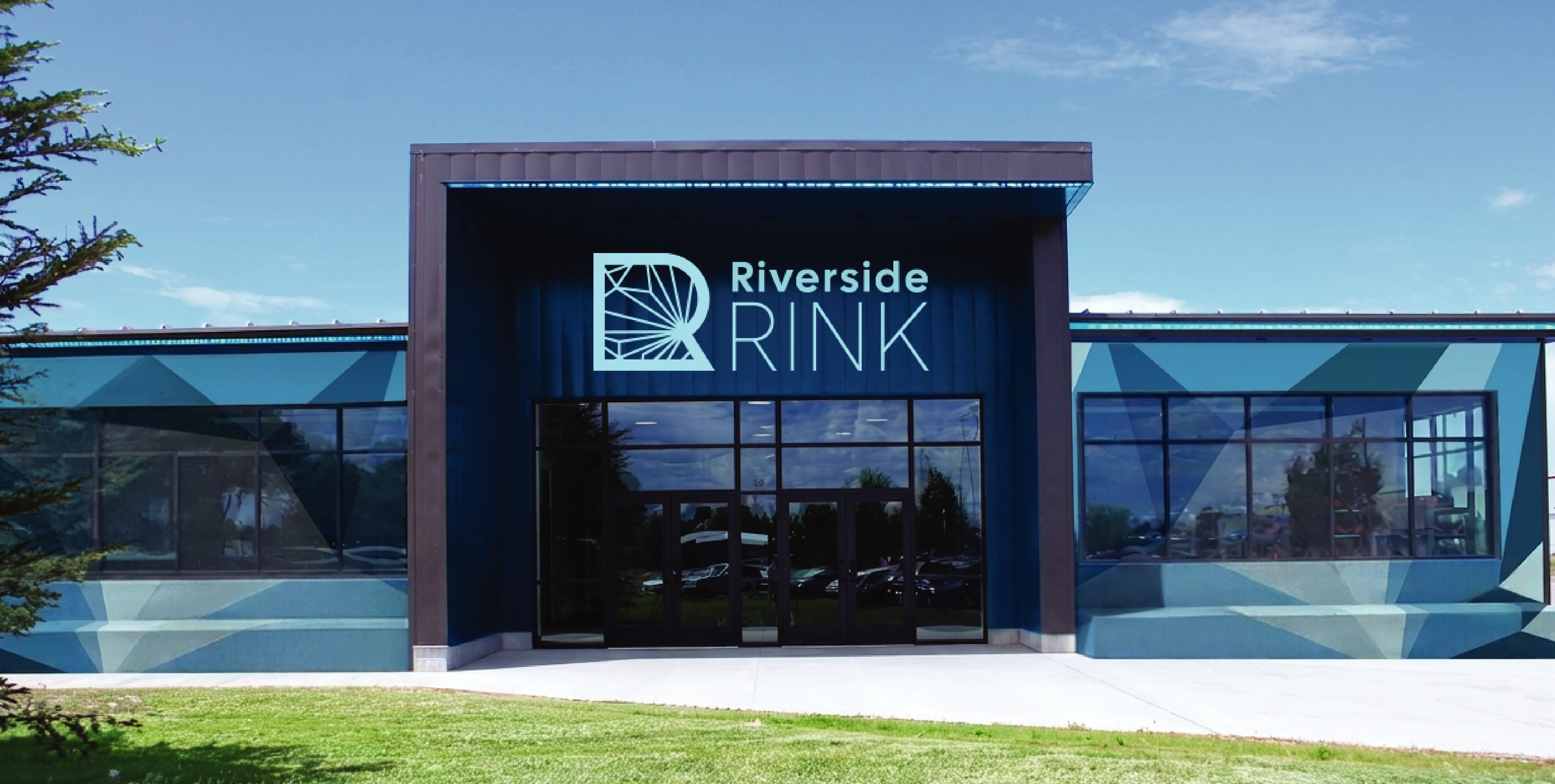 A modern building with glass windows and a sign that reads 'Riverside Rink' with a stylized rink logo, surrounded by a green grass lawn.