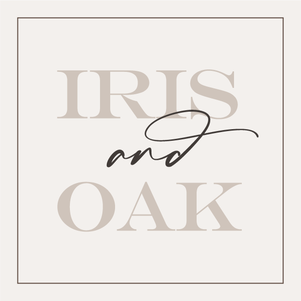Graphic design with the text 'IRIS and OAK' in large, light beige letters with 'and' in black cursive, on a light background with a thin border.