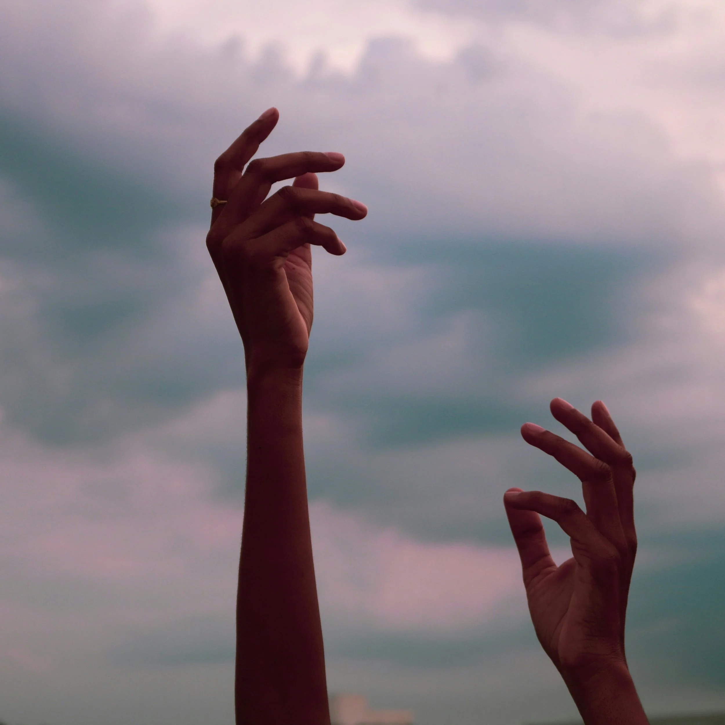Hands reaching up toward the sky