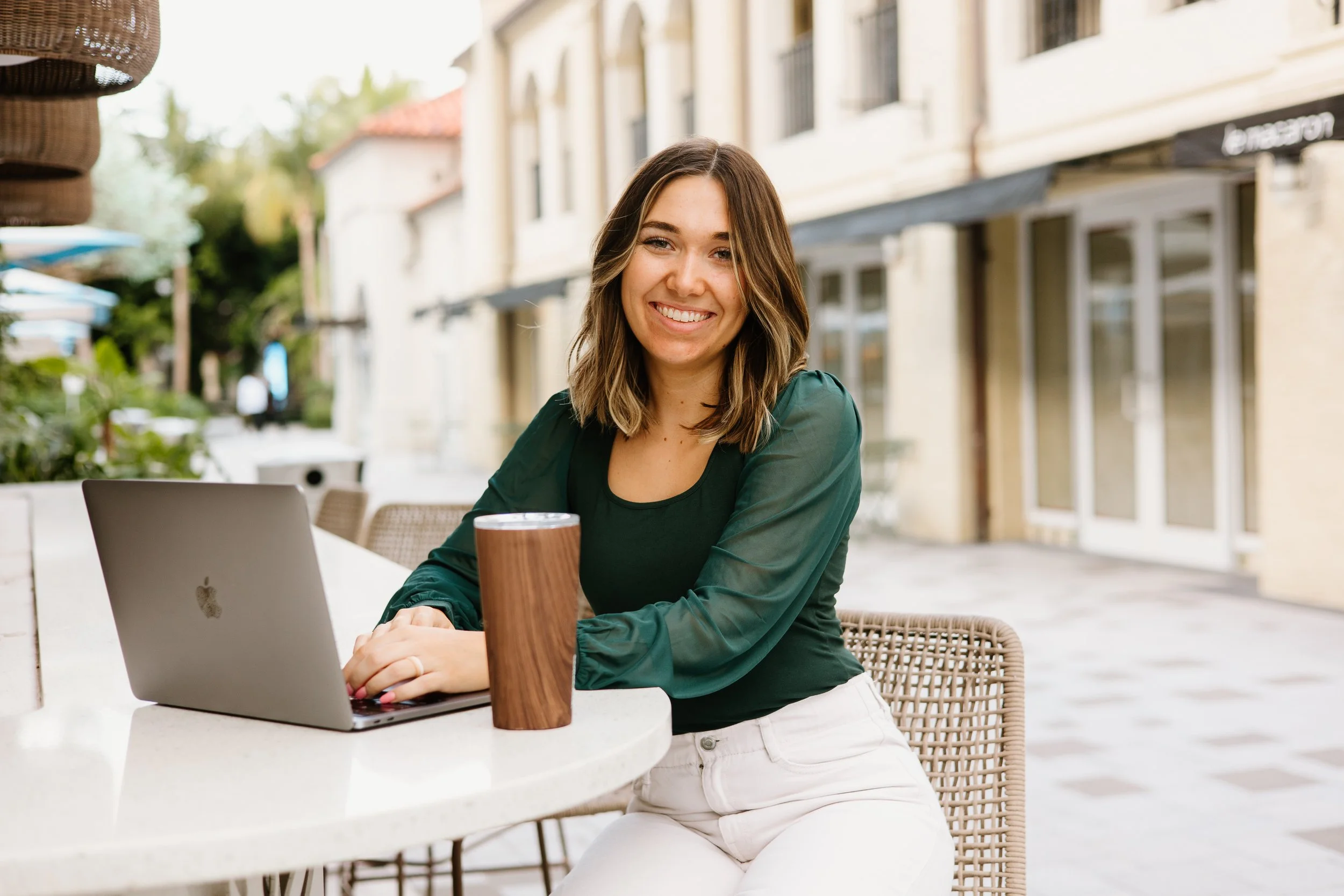 Kailyn España, maternal mental health speaker and counselor, smiling at her laptop in Boca Raton