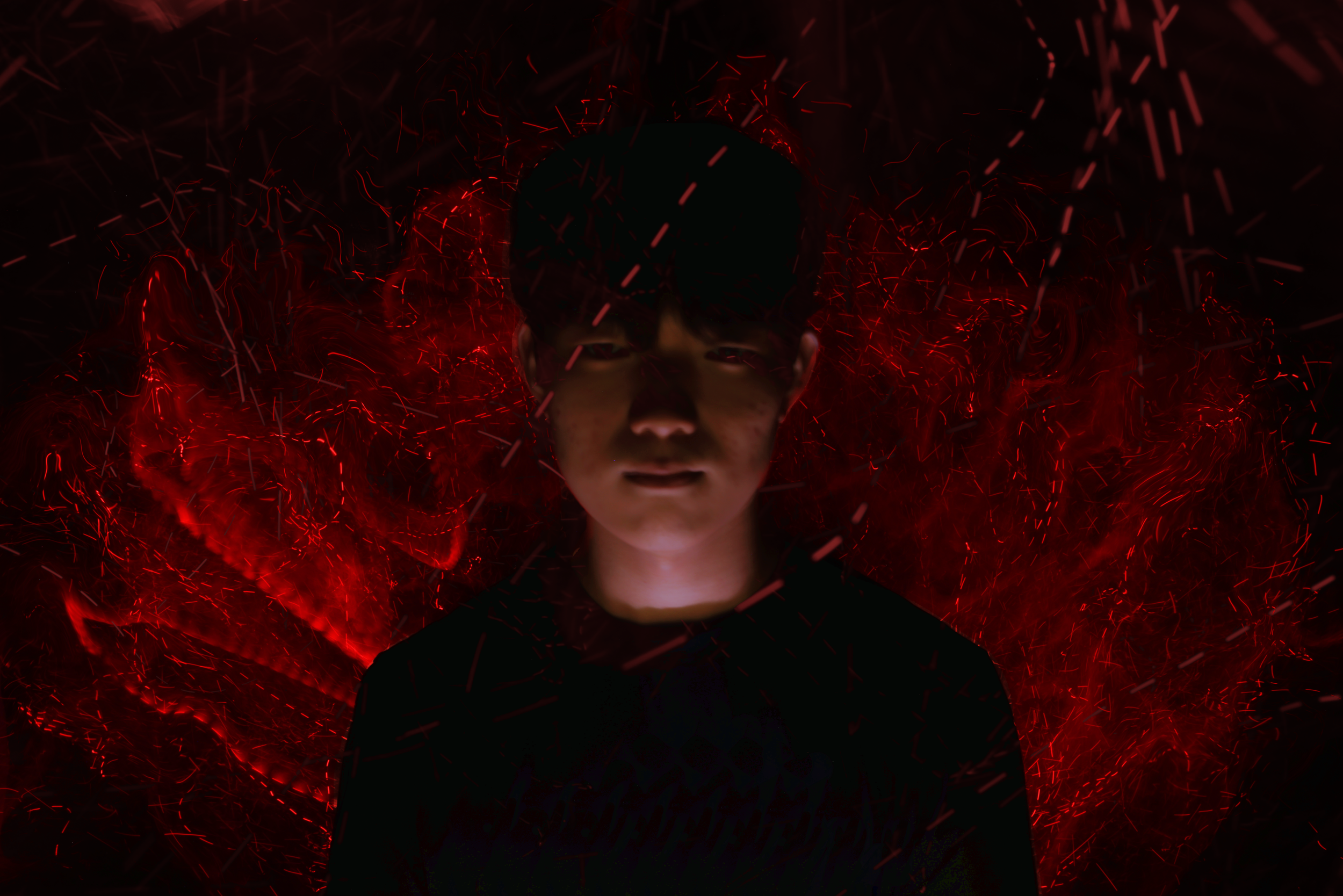 A person with dark hair and a dark cap surrounded by swirling red and black light patterns, creating an intense, dramatic scene.