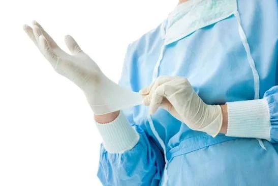 A healthcare professional putting on a disposable glove.