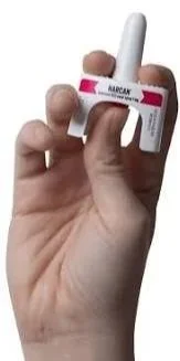 Hand holding a small white device with a red and black label reading 'AARP.'