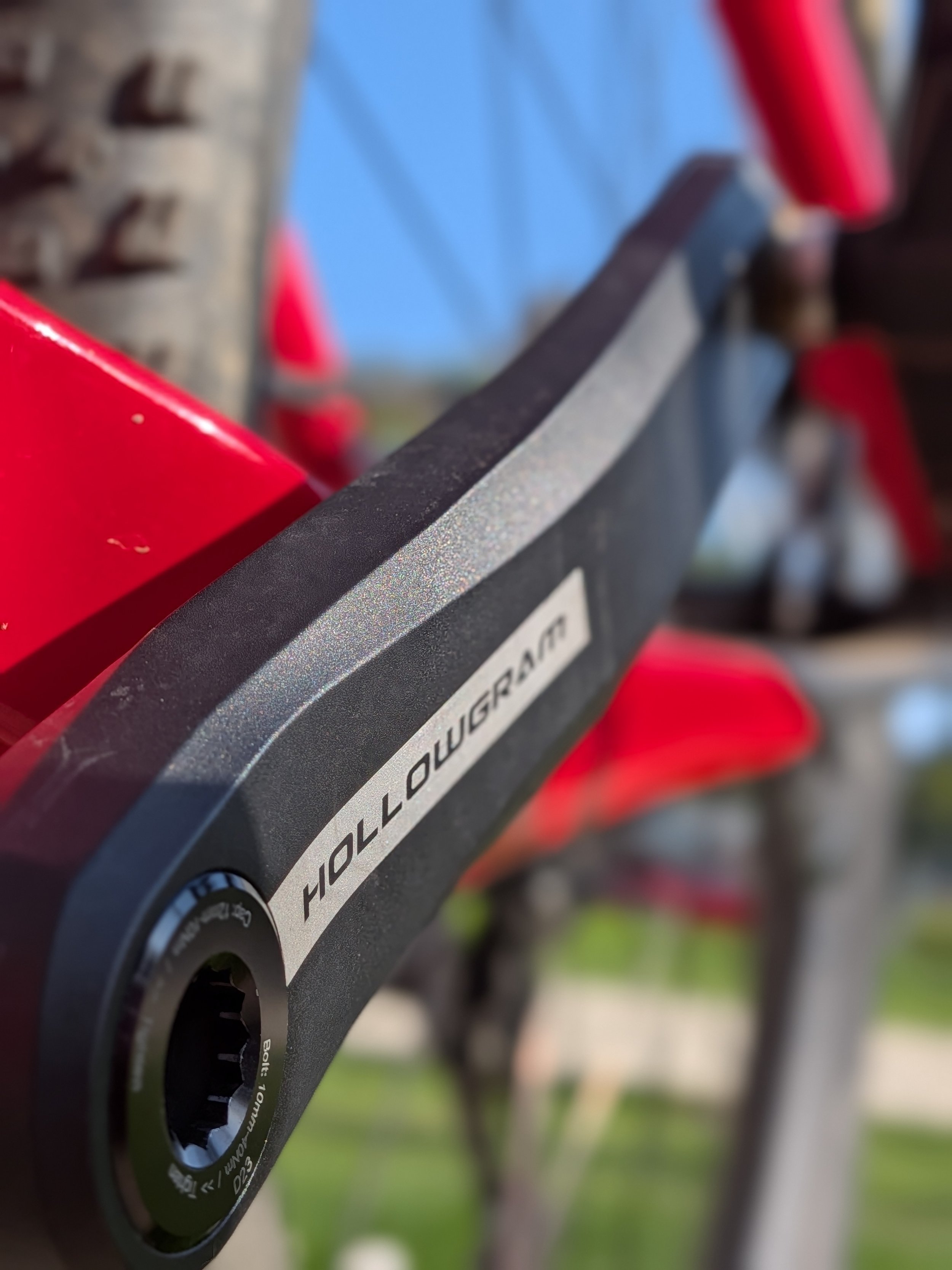 Close-up of the engraved disc inside a bicycle headset with visible brand and specifications, mounted on a red bicycle with a blurred background.