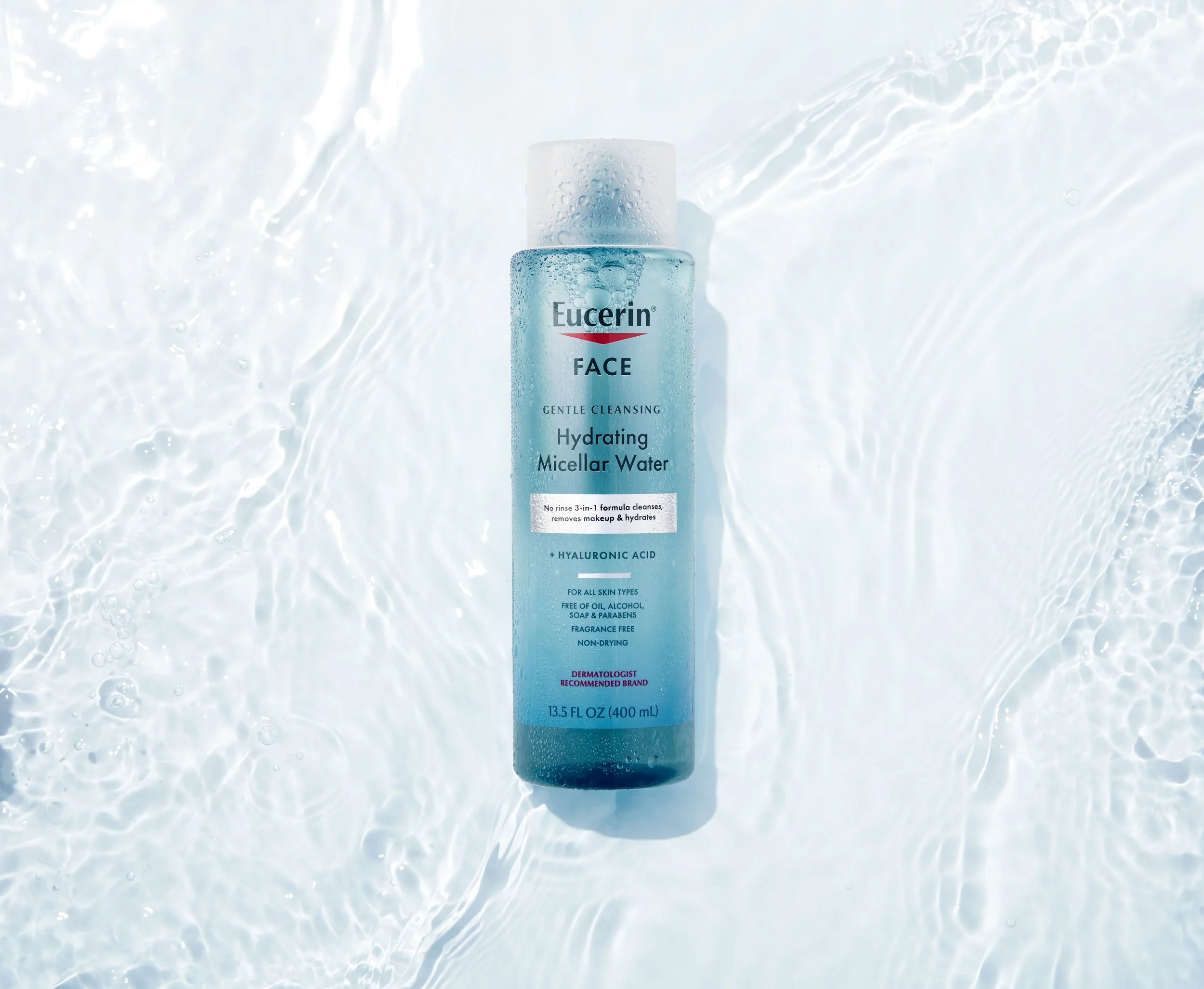A bottle of Eucerin face hydrating micellar water floating in water with ripples and bubbles.