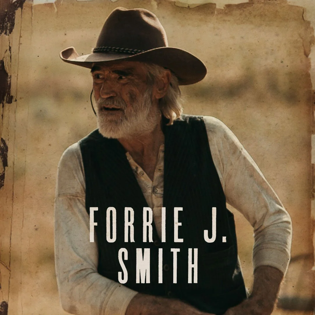 A bearded elderly man wearing a cowboy hat, a cream-colored shirt, and a black vest, with the text 'FORRIE J. SMITH' overlayed on the image.