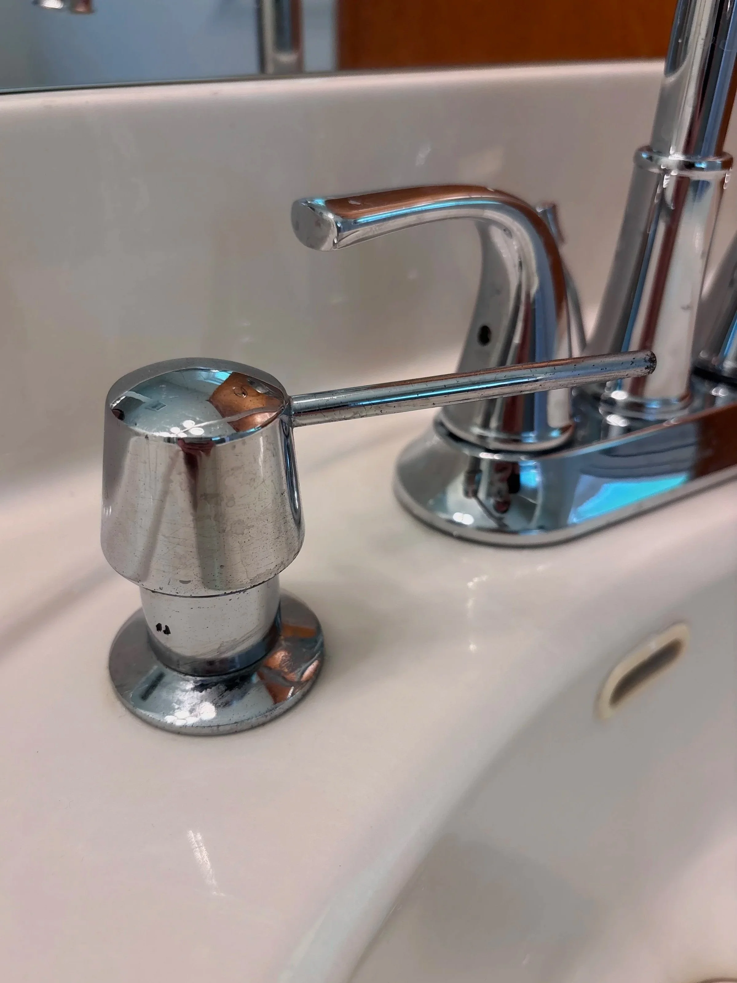 Chrome bathroom faucet and sink in a bathroom.