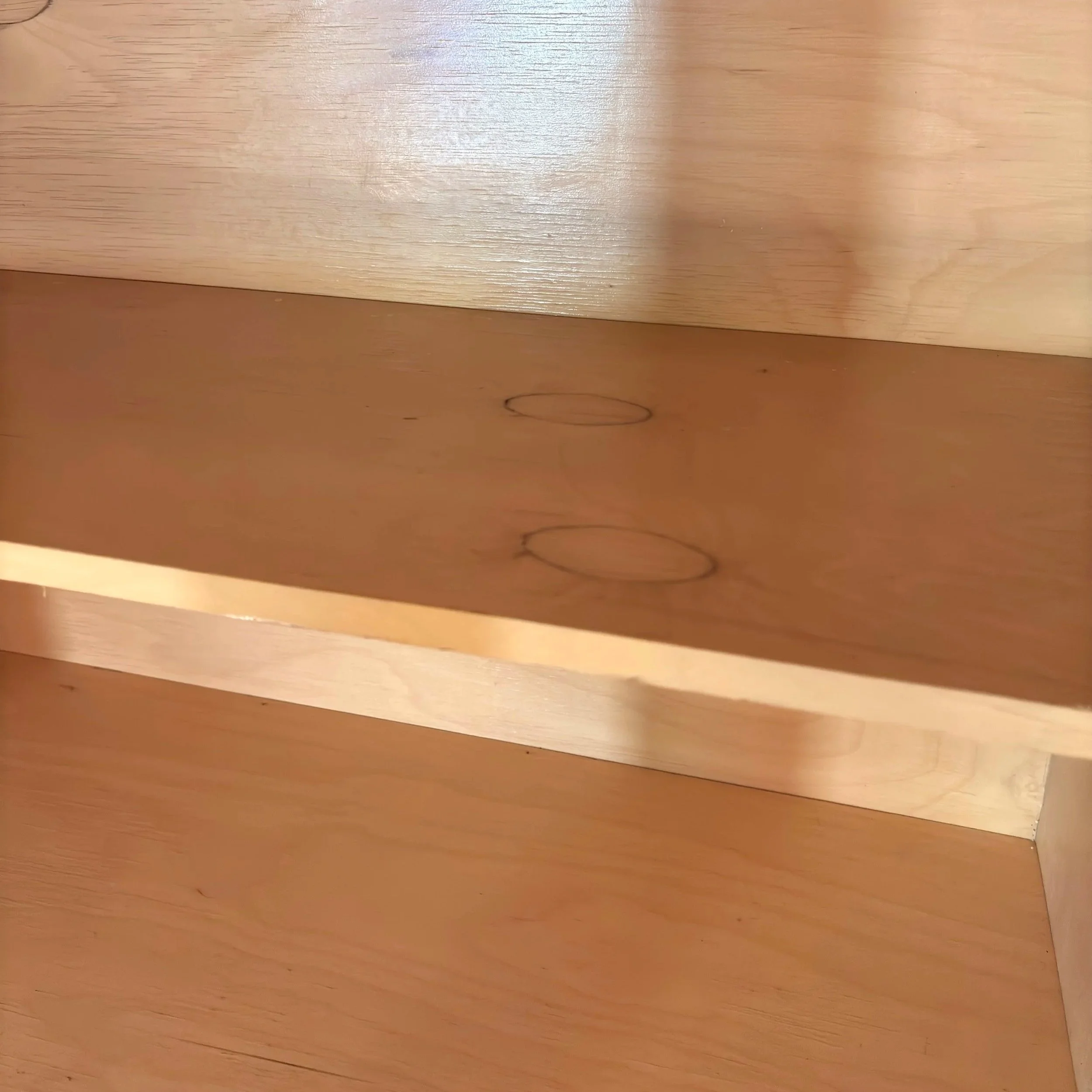 Close-up view of a wooden surface with visible wood grain and knots.