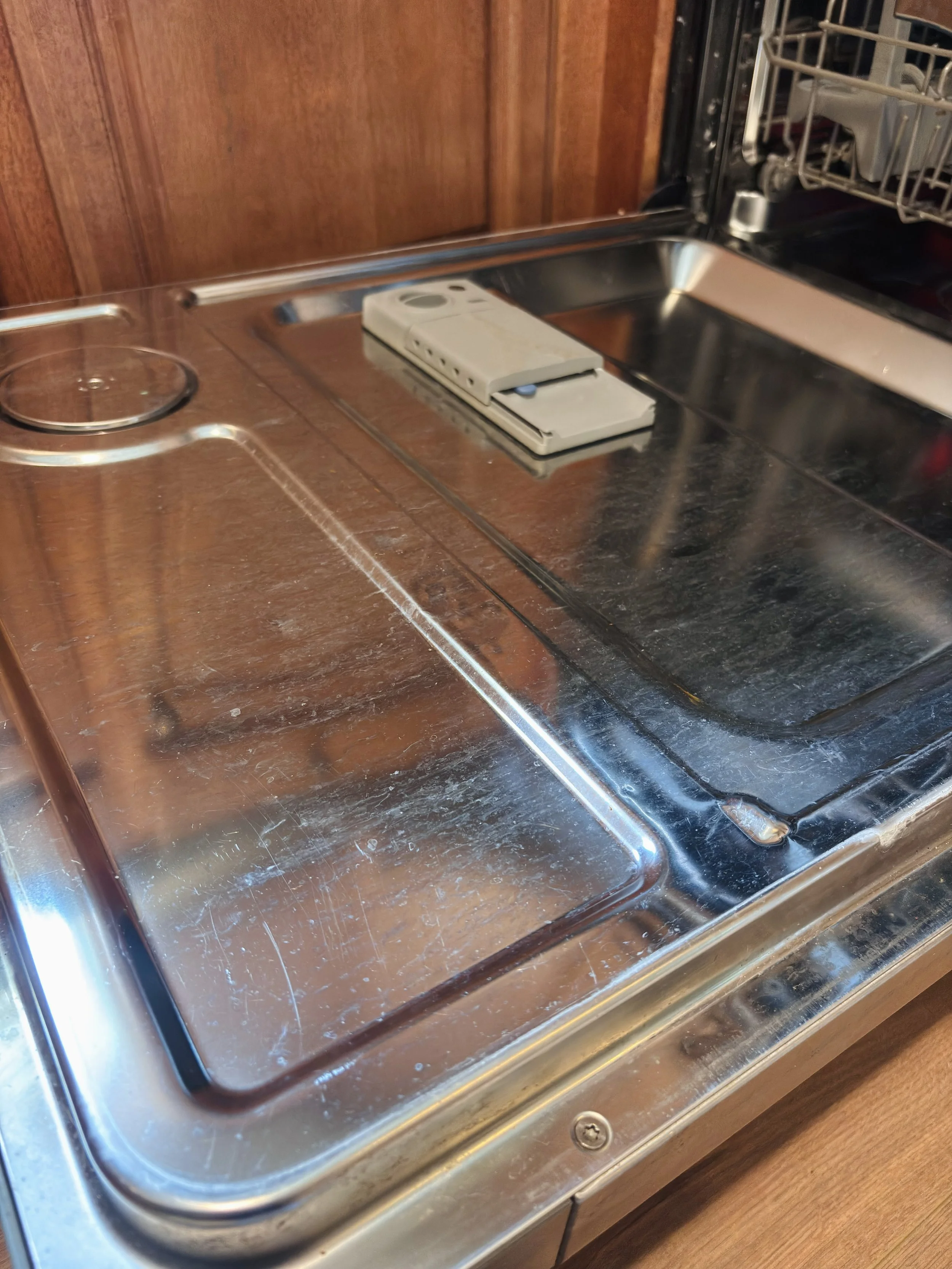 A stainless steel countertop with a built-in stove and a white remote control placed on it.