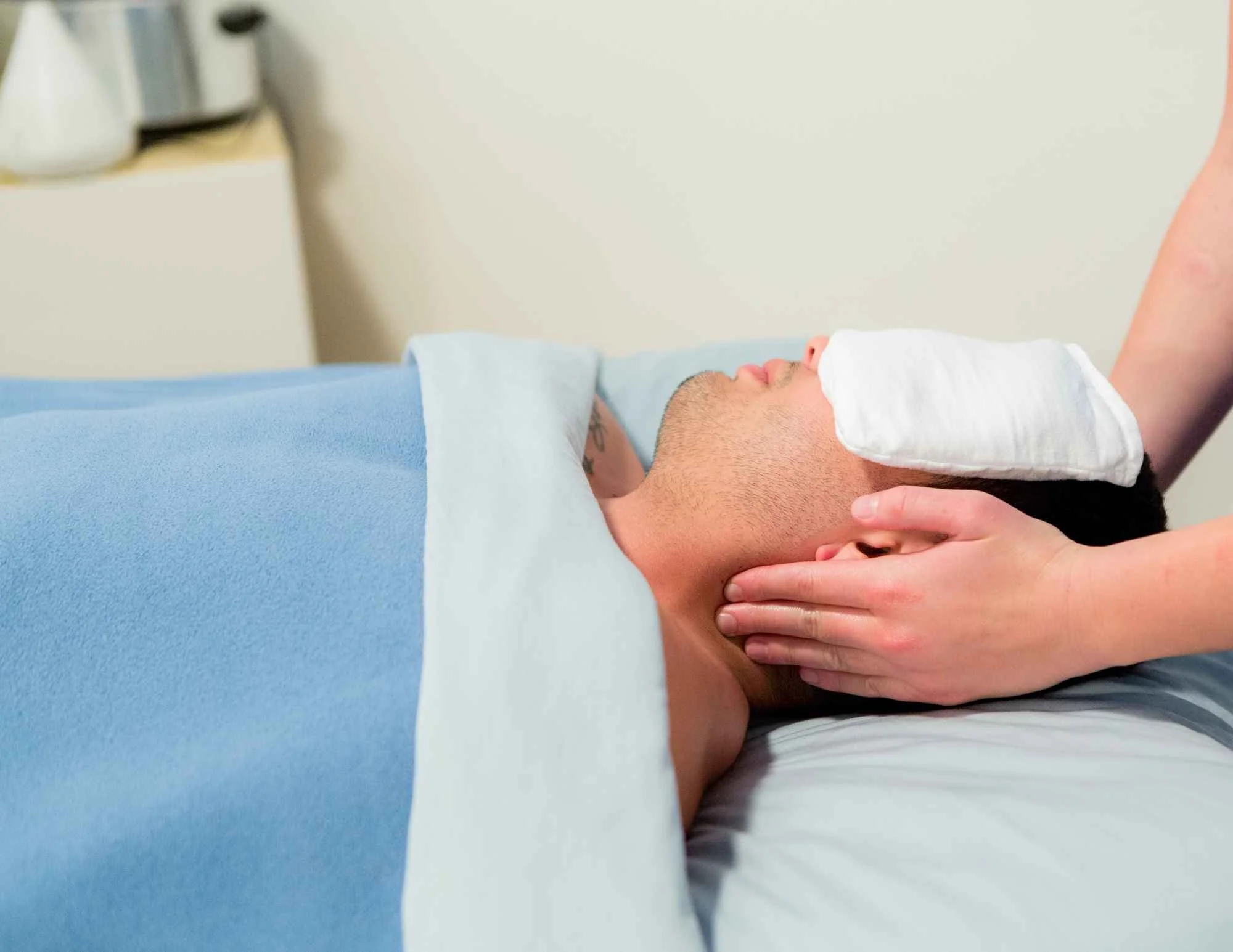 Man receiving a relaxing AromaTouch Treatment. A whole-body wellness treatment to boost immune function, improve circulation, and reduce stress.