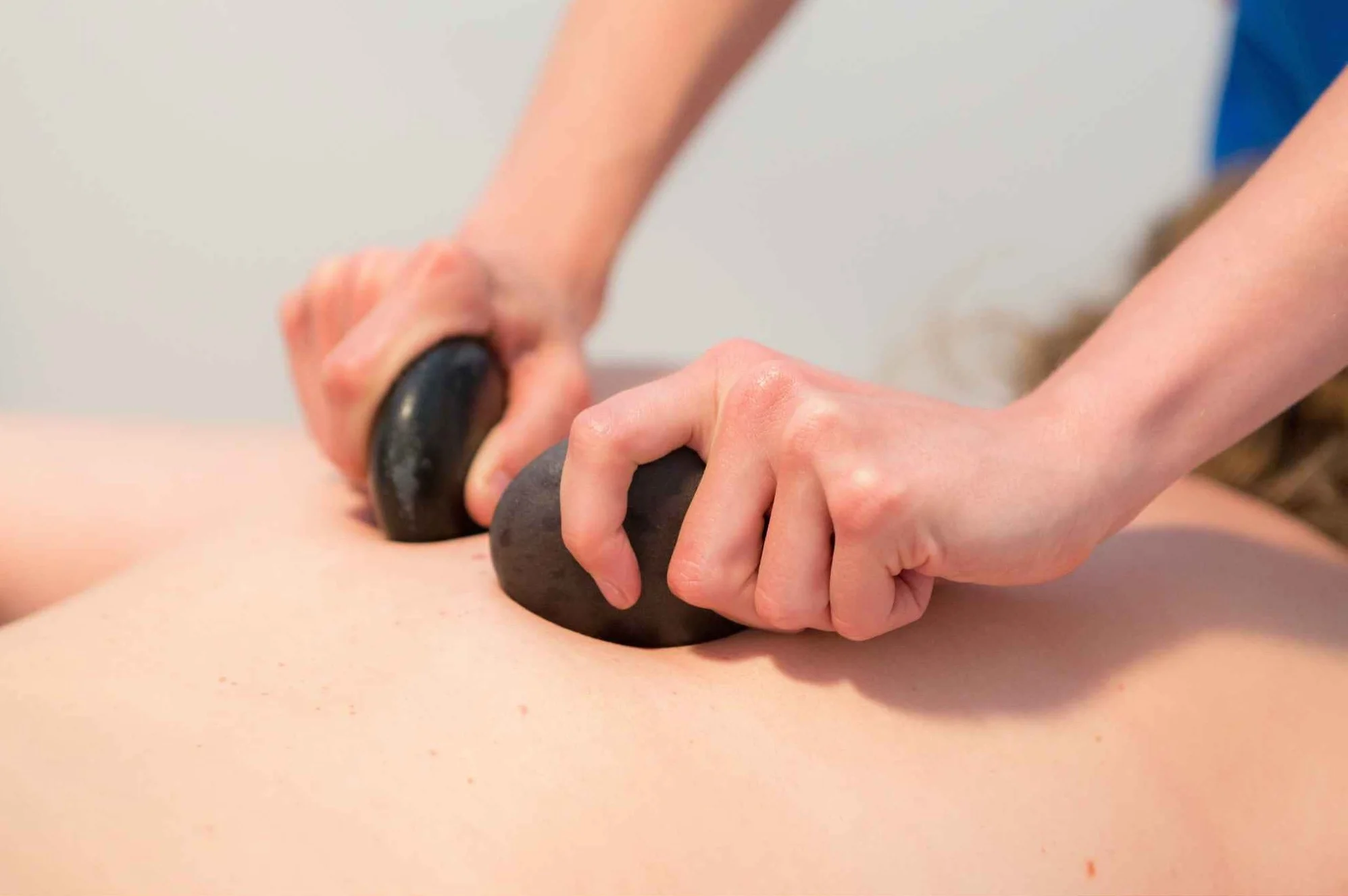 Hot stone massage to release muscle tension at Blue Skies Massage and Wellness Spa in Longmont, Colorado.