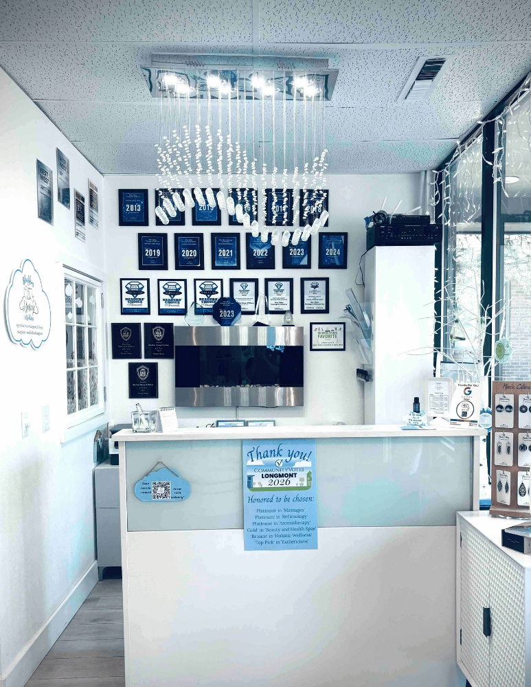 Front desk of Blue Skies Massage and Spa in Longmont, CO with a wall of awards.