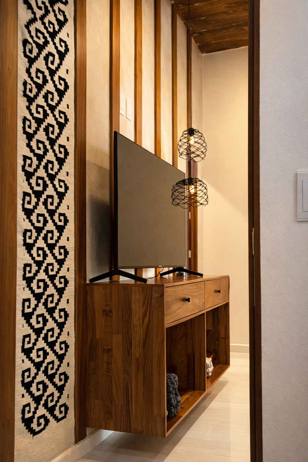 Mueble de madera con televisión y lámparas de estilo moderno en una sala.