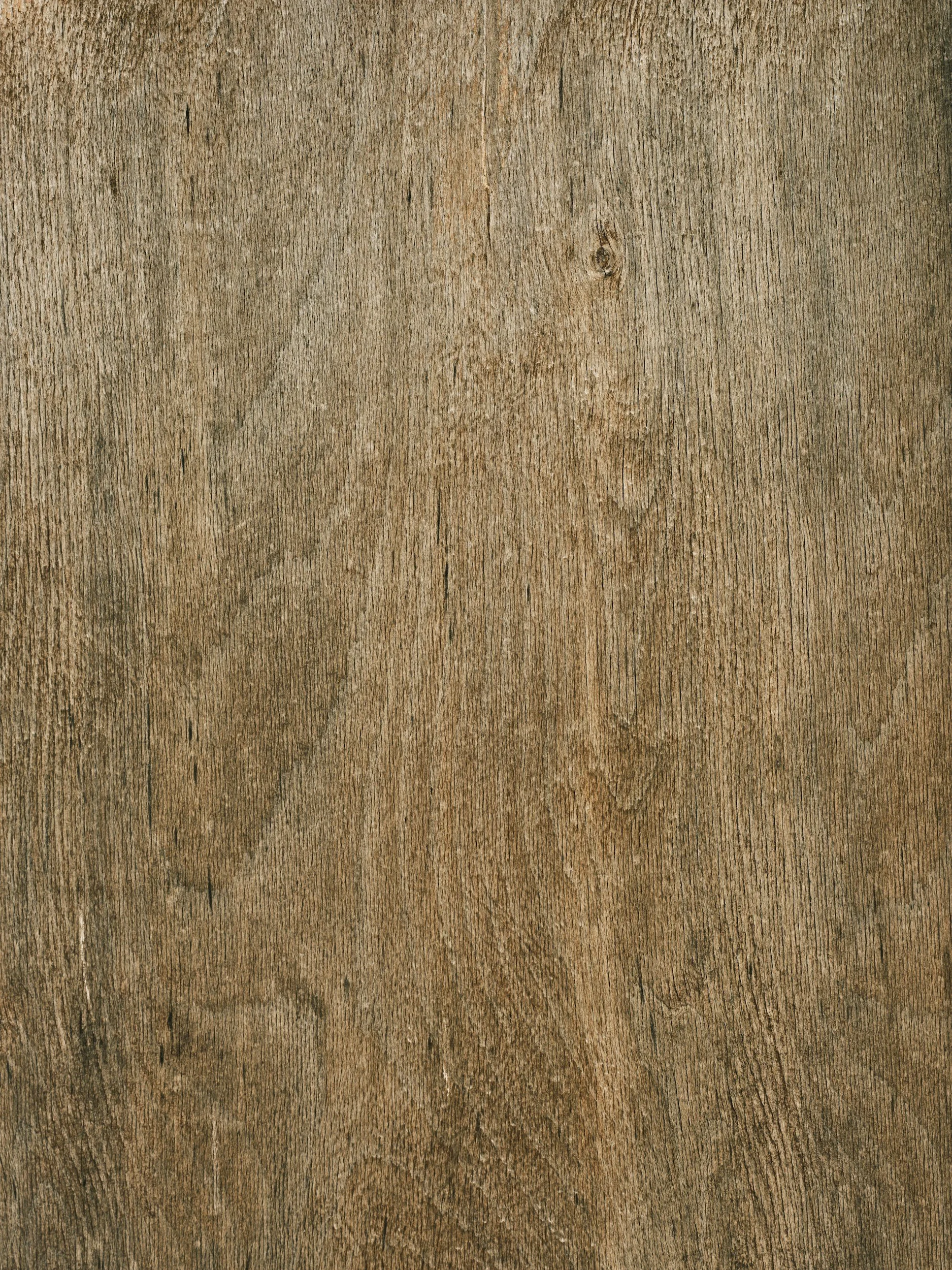 Close-up of a wooden surface with visible grain, knots, and textured pattern.