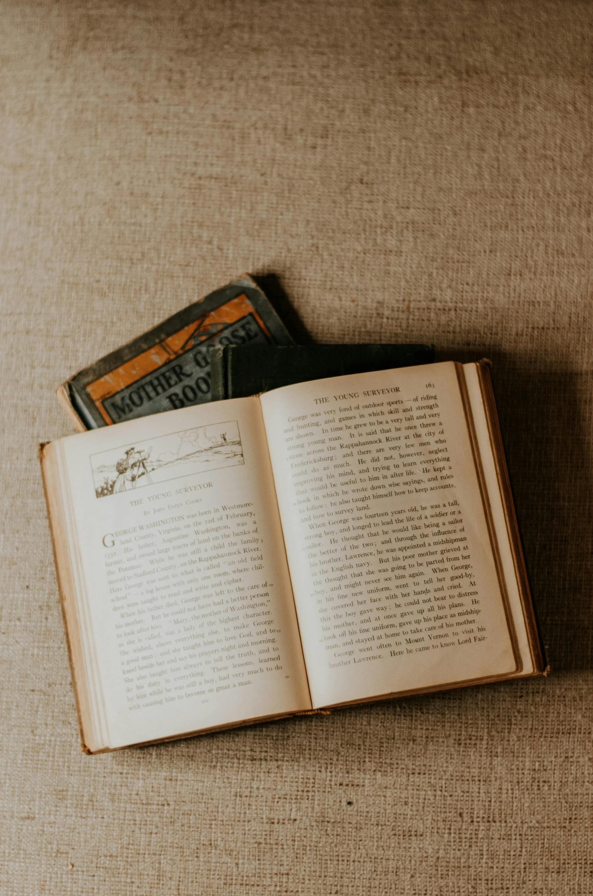 photo of open book with other books by Nani Chavez from unsplash.com