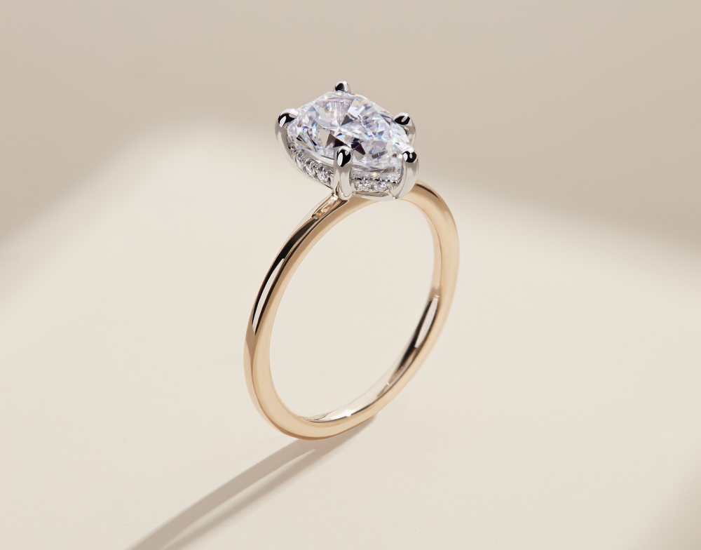 A close-up of a gold ring with a large center diamond and smaller diamonds on the band.