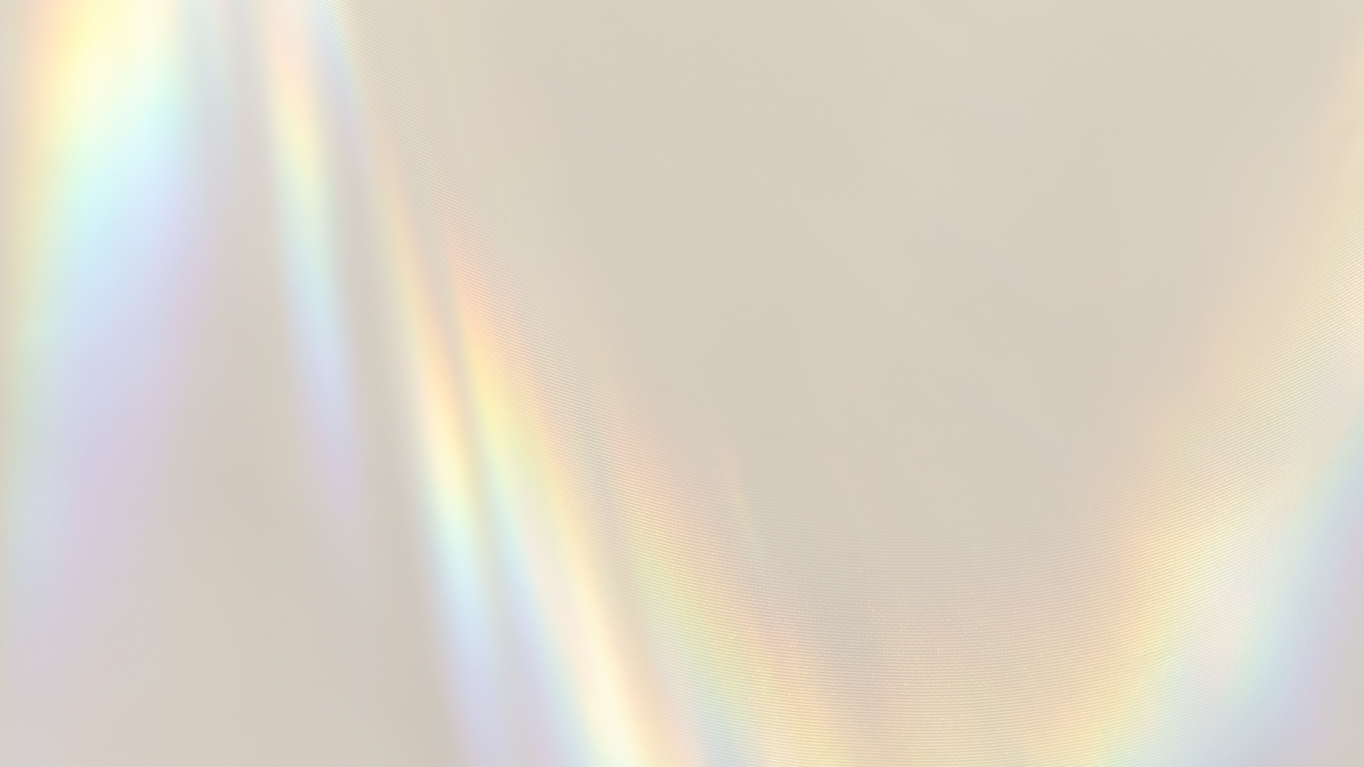 Blurred abstract background with soft, pastel rainbow-like light spectrum.
