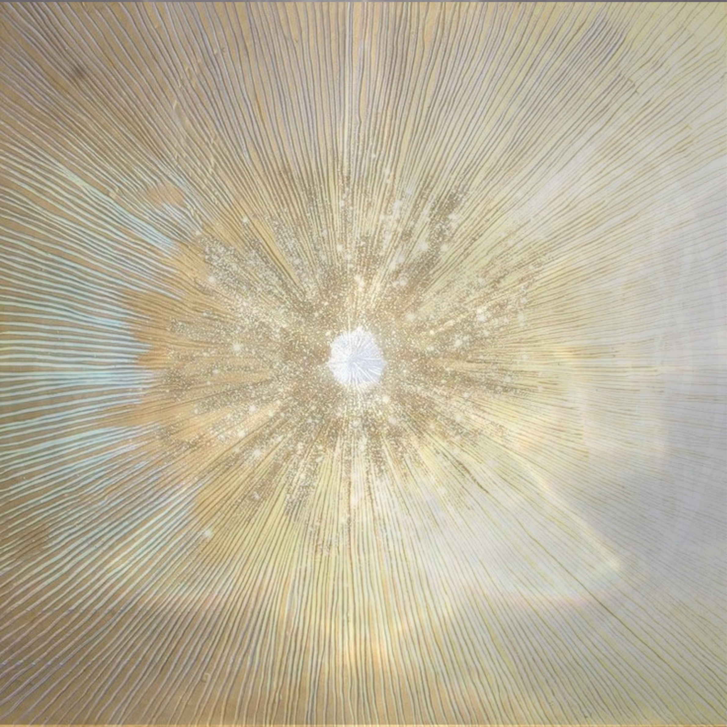 A close-up of a textured surface with radiating lines and a small bright white light or reflection at the center, creating a pattern of concentric circles.