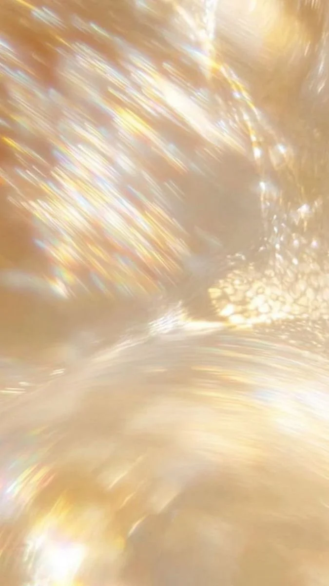 Close-up of a shiny, reflective golden surface with light reflections and bokeh effects.