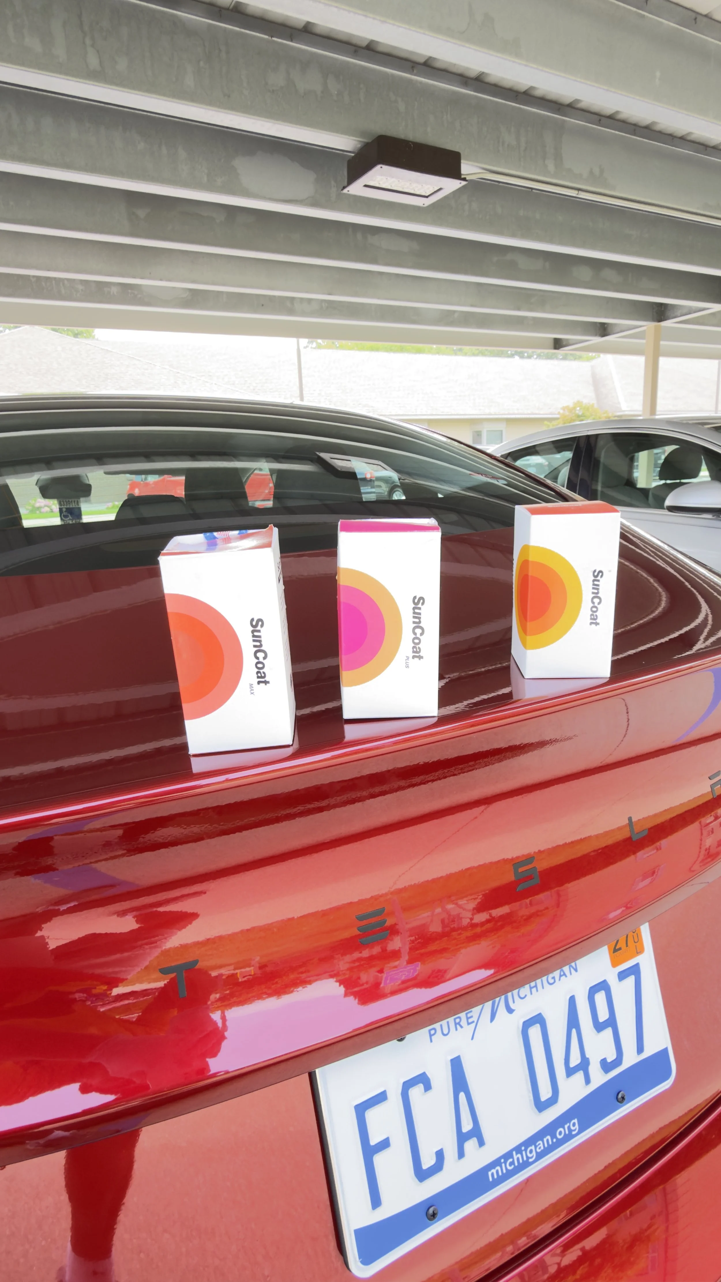 Red Tesla model 3 parking ceramic coating in grand haven Michigan