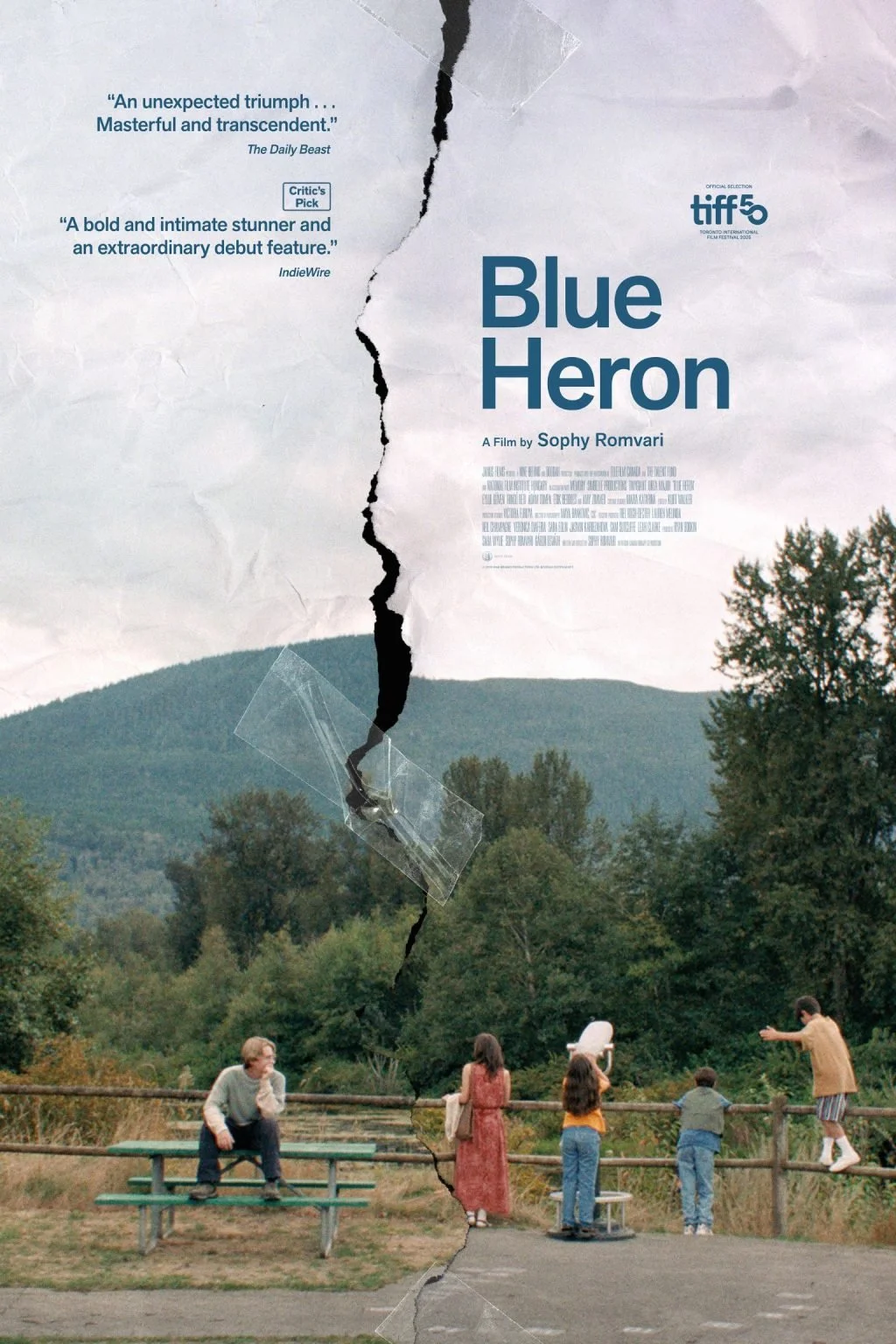 Poster for the film 'Blue Heron' showing a torn paper design with quote, film title, and scene of children and a woman near a scenic outdoor setting with trees and mountains.