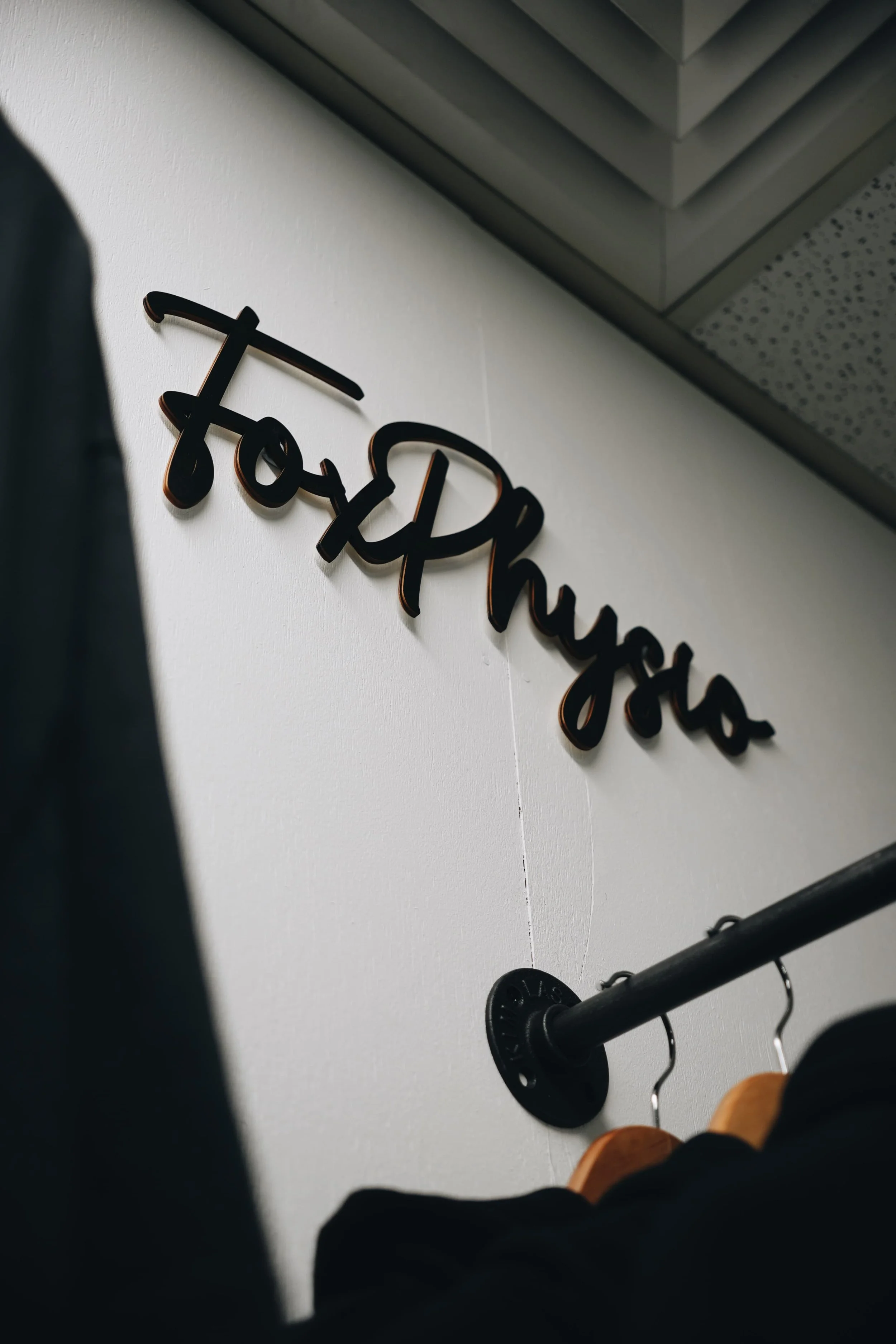 Close-up of a wall with a black cursive sign that says 'today' and gym equipment hanging on the wall beneath it.