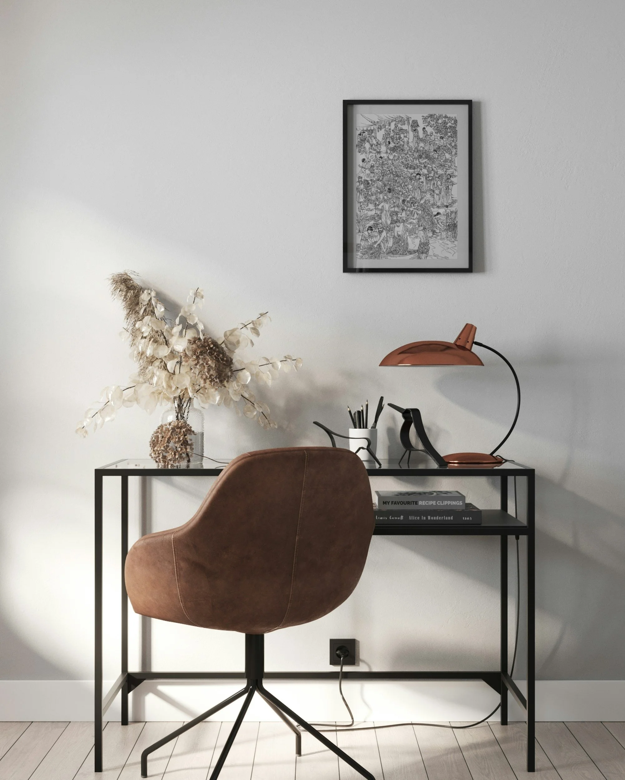 A home workspace with a black desk, a brown swivel chair, a dried flower arrangement, and a framed black and white artwork on a white wall. Also features a copper desk lamp, a container with pens, and books titled 'My Favourite Recipe Clippings', 'Lewis Carroll Alice in Wonderland', and '1865'.