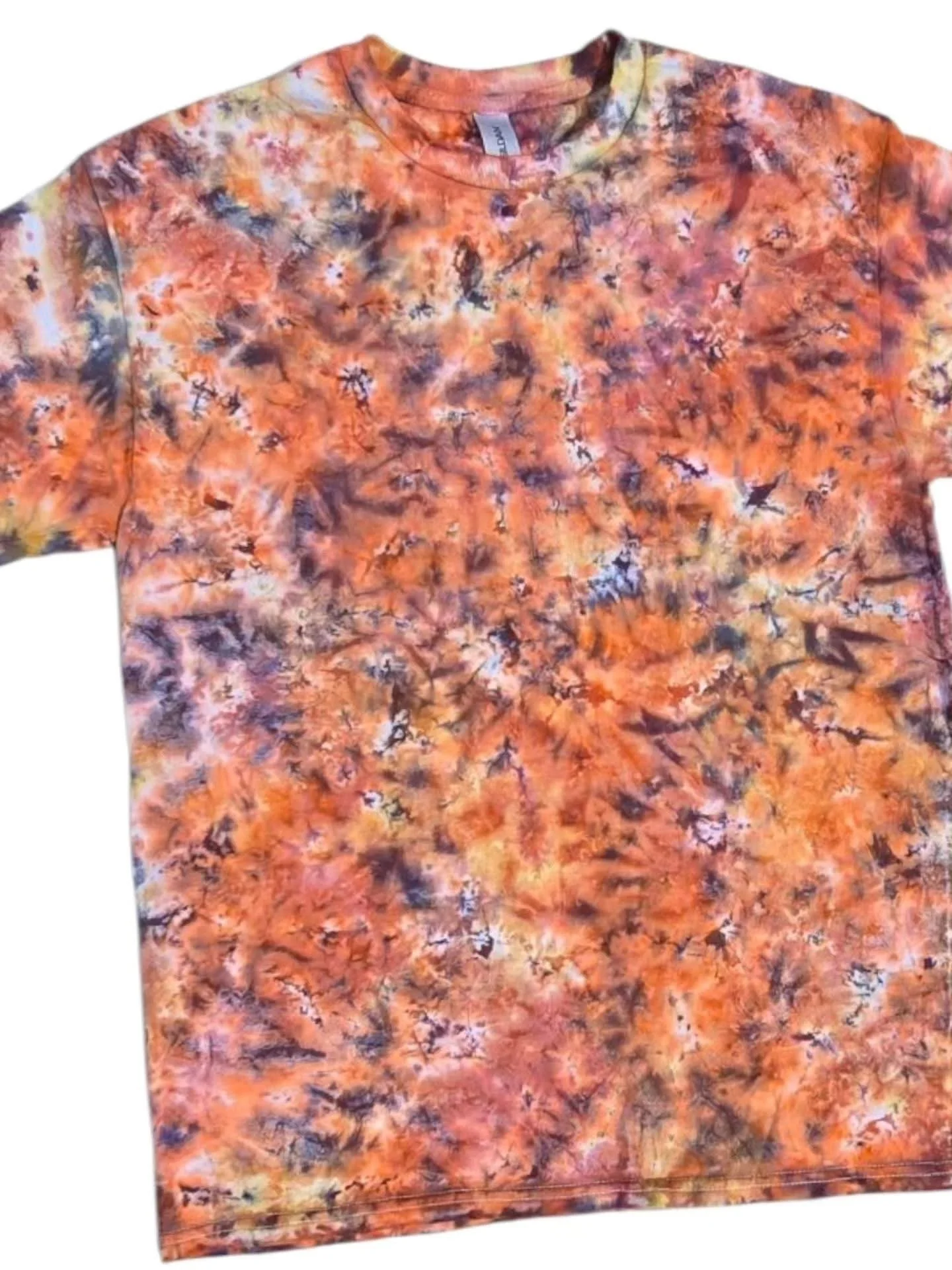 T-shirt with a multicolored, abstract, tie-dye pattern in shades of orange, yellow, purple, and black, featuring a crew neck and short sleeves.