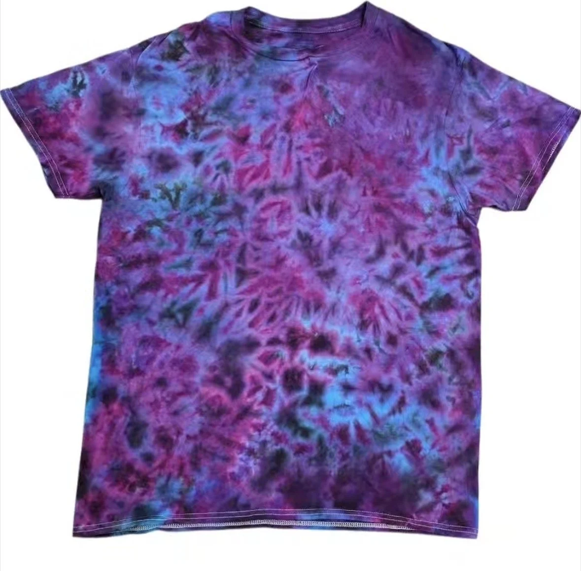 A tie-dye t-shirt with purple, pink, blue, and black patterns.